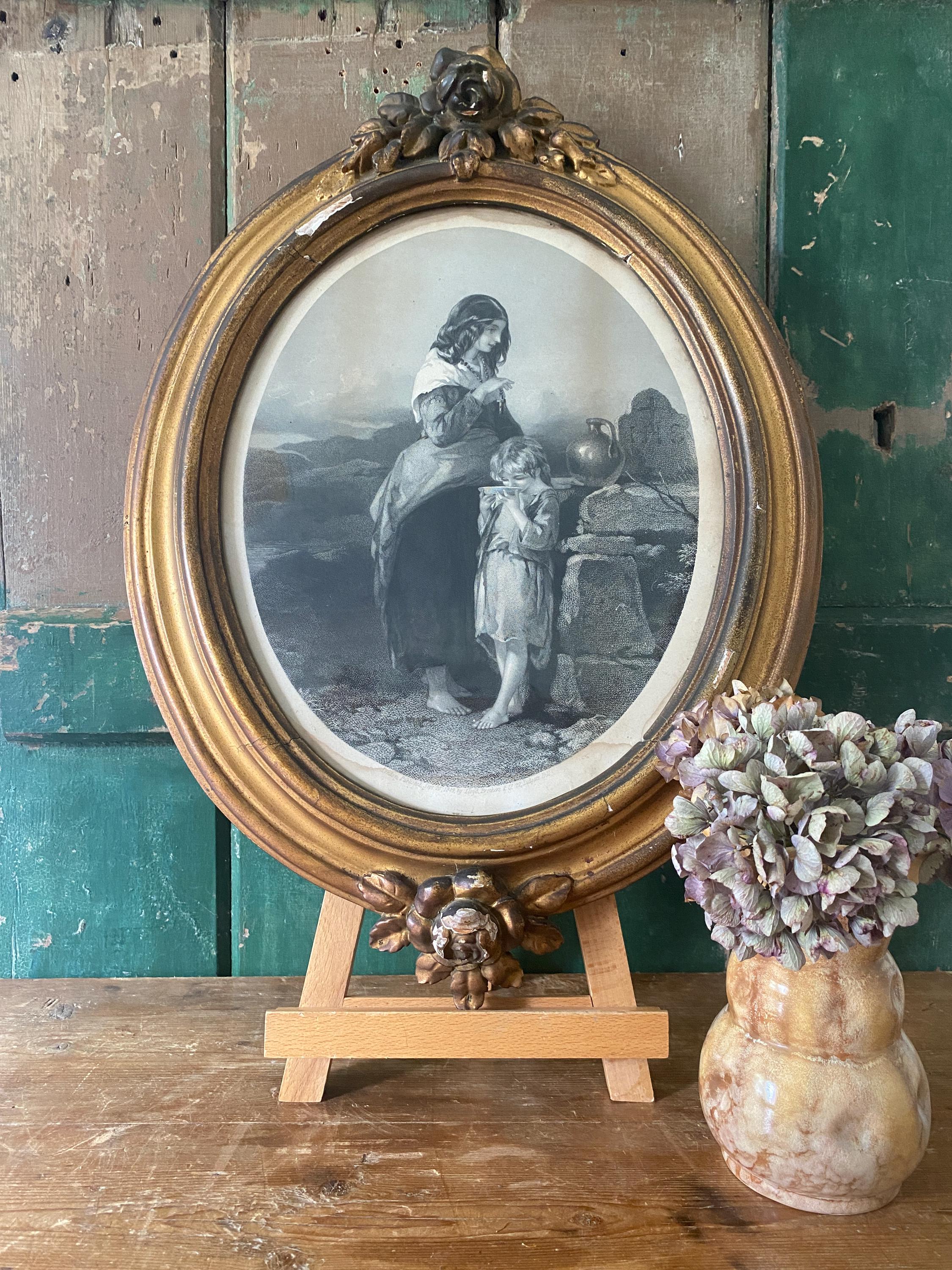 Antique gilt oval frame with a black and white portrait of two figures