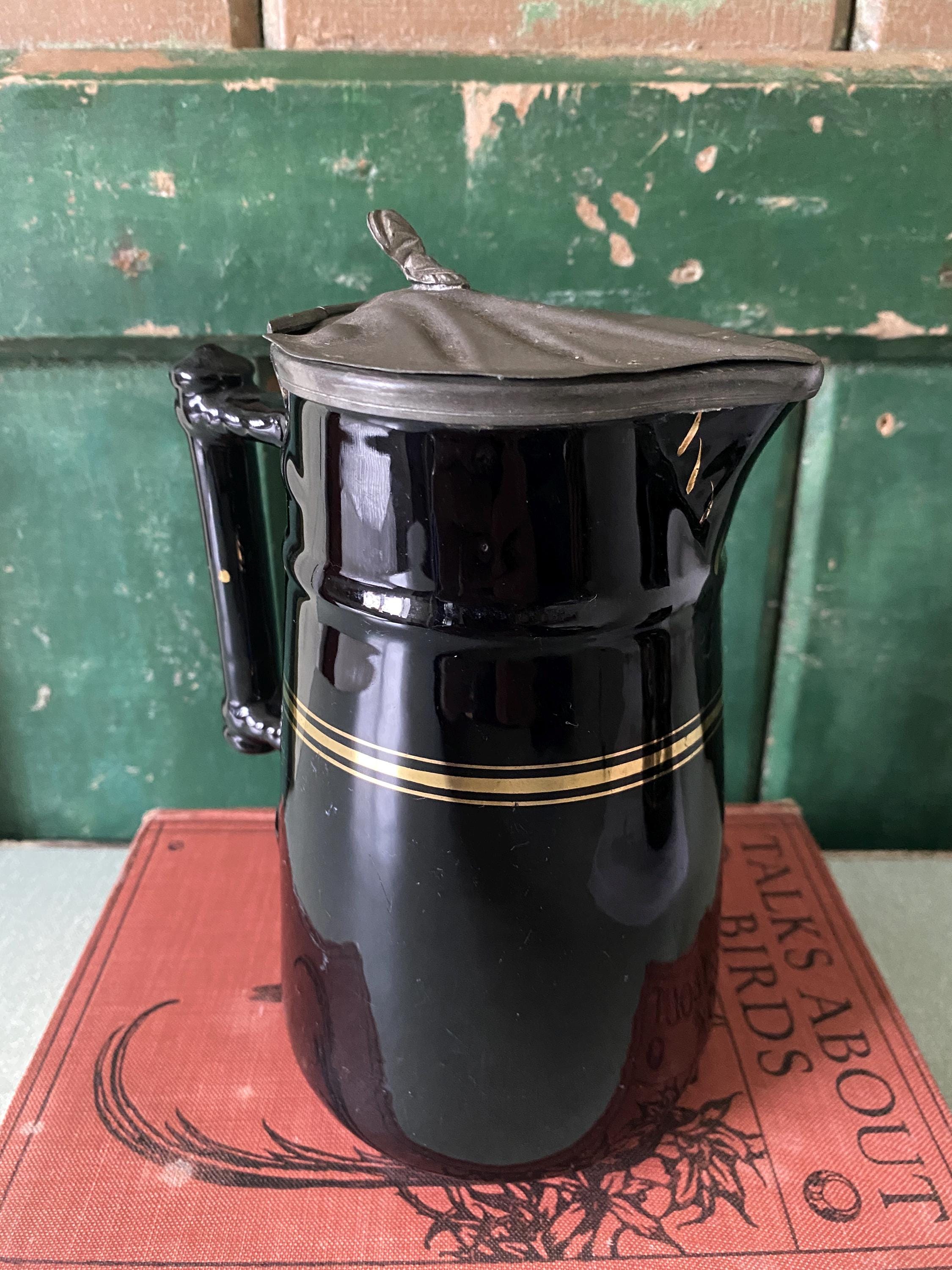 Black ceramic pitcher with gold stripe and hinged metal lid