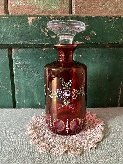 Decorative red glass decanter with floral pattern