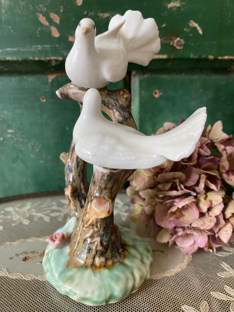 Decorative figurine of two white doves on a branch