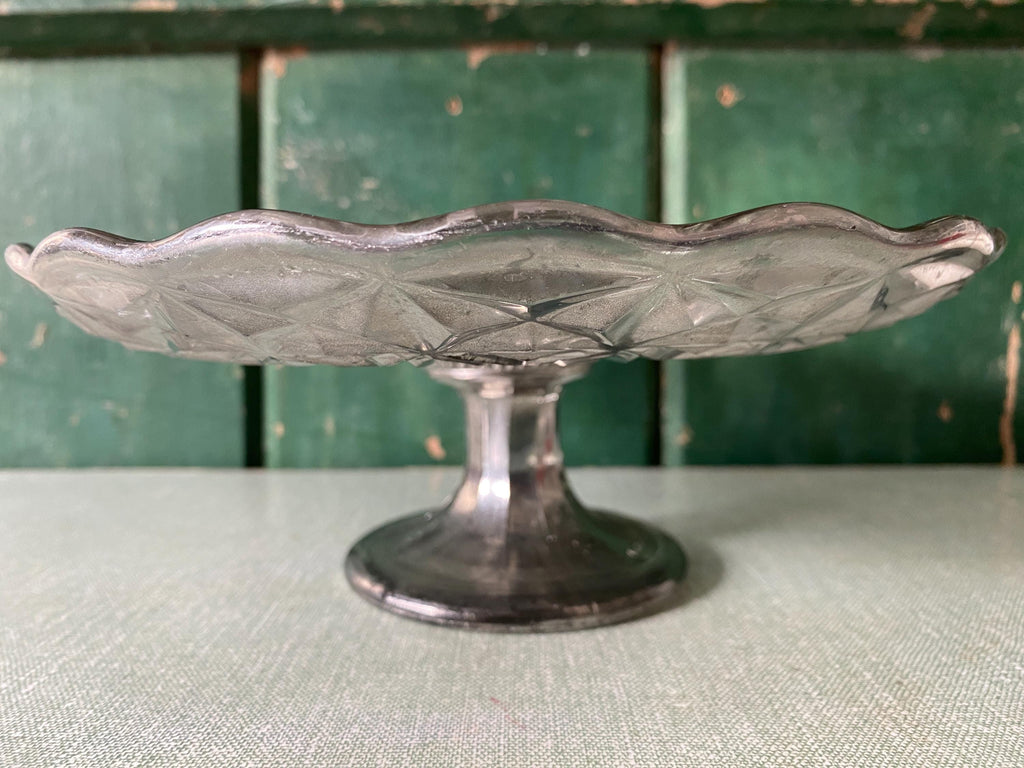 Side view of a decorative mercury glass cake stand 