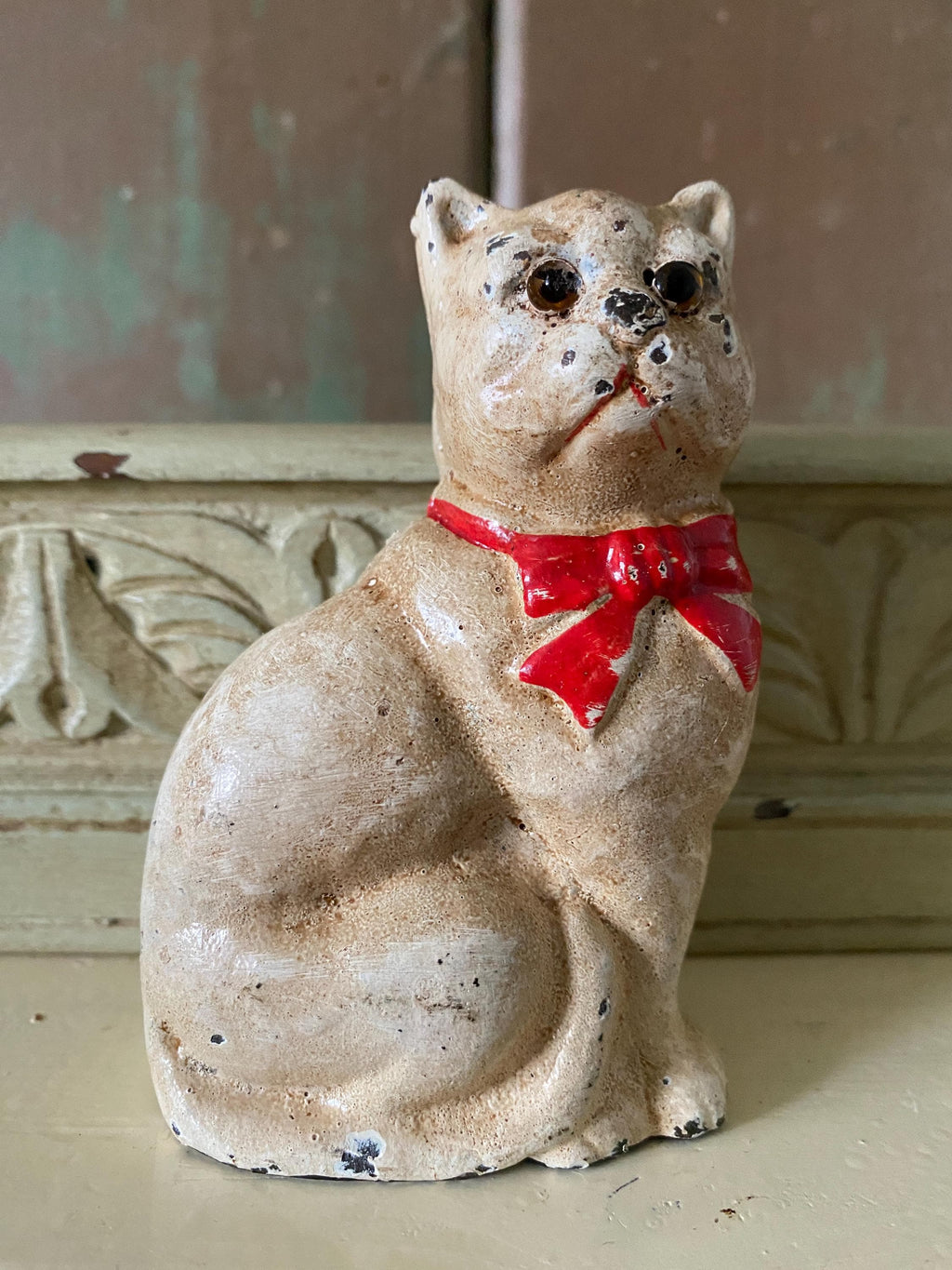Small figurine of a white cat  with a red bow