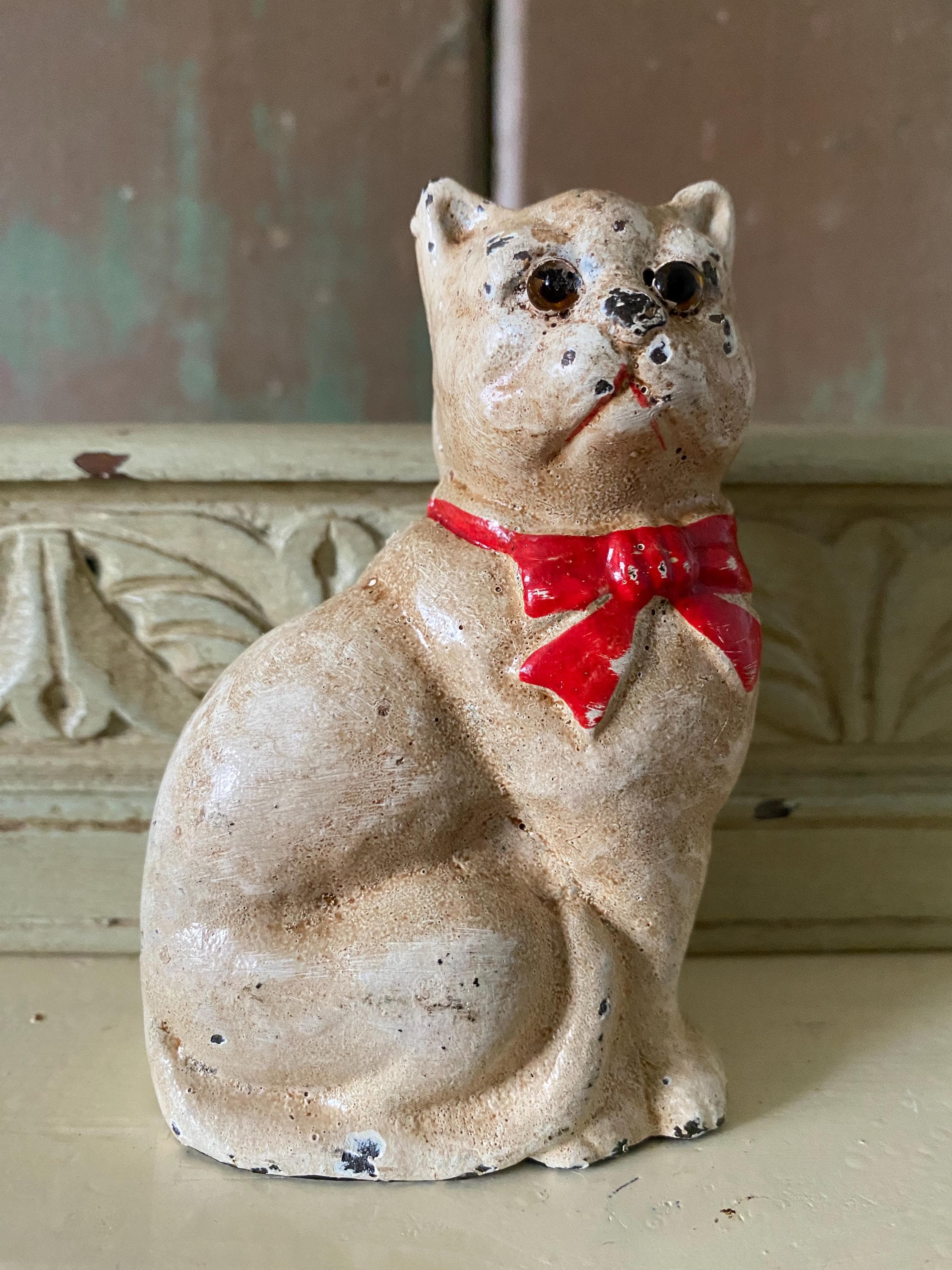 Small figurine of a white cat  with a red bow