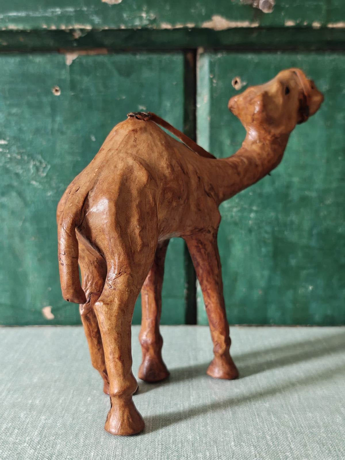Back view of a brown leather covered camel figurine