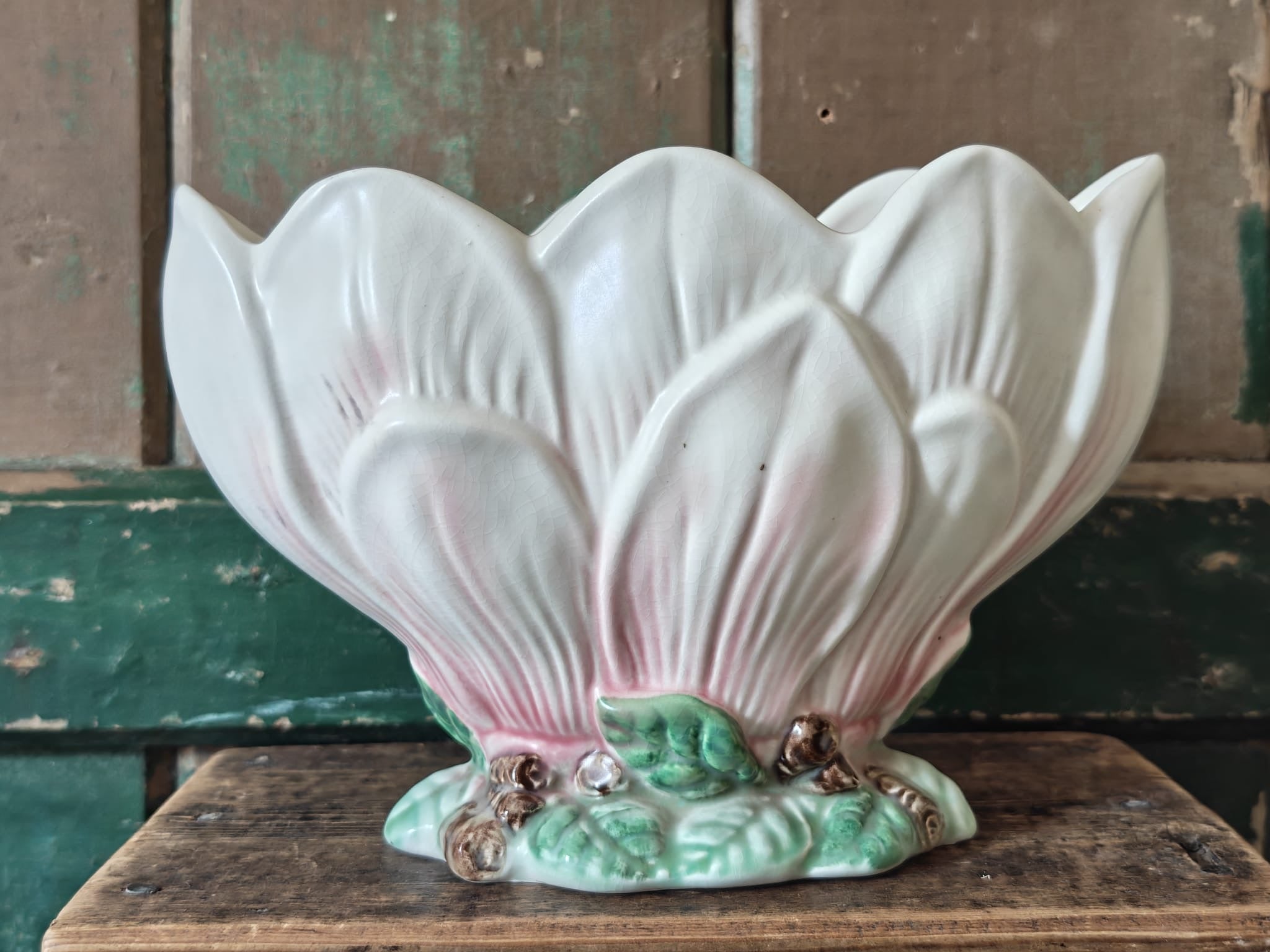 A vintage-style ceramic flower vase formed as a pink and green magnolia flower.