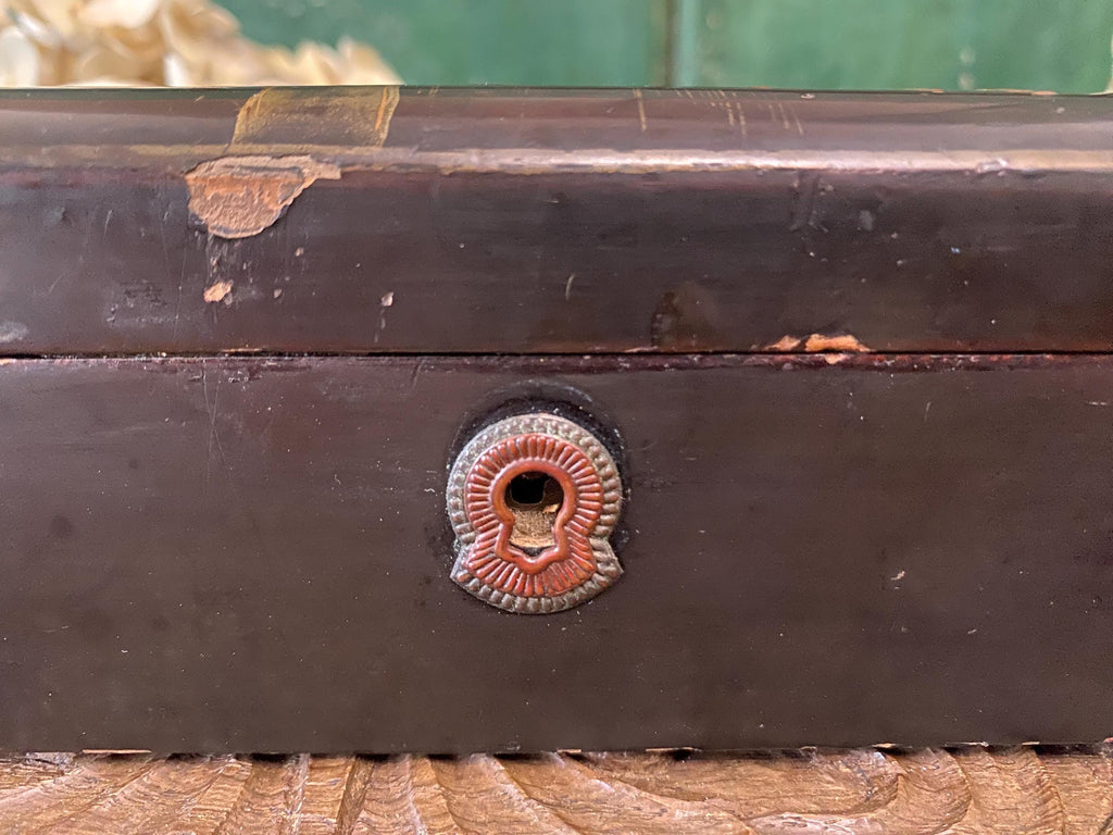 Close-up of a dark wooden box with a decorative keyhole