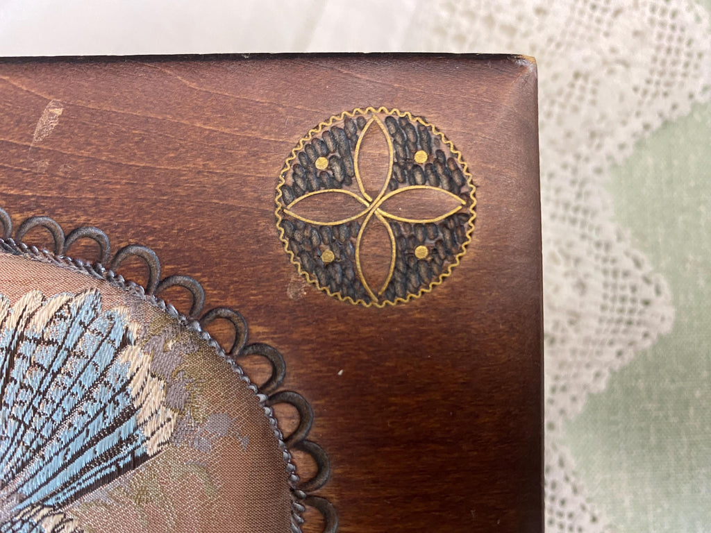 Wooden box with decorative floral emblem 