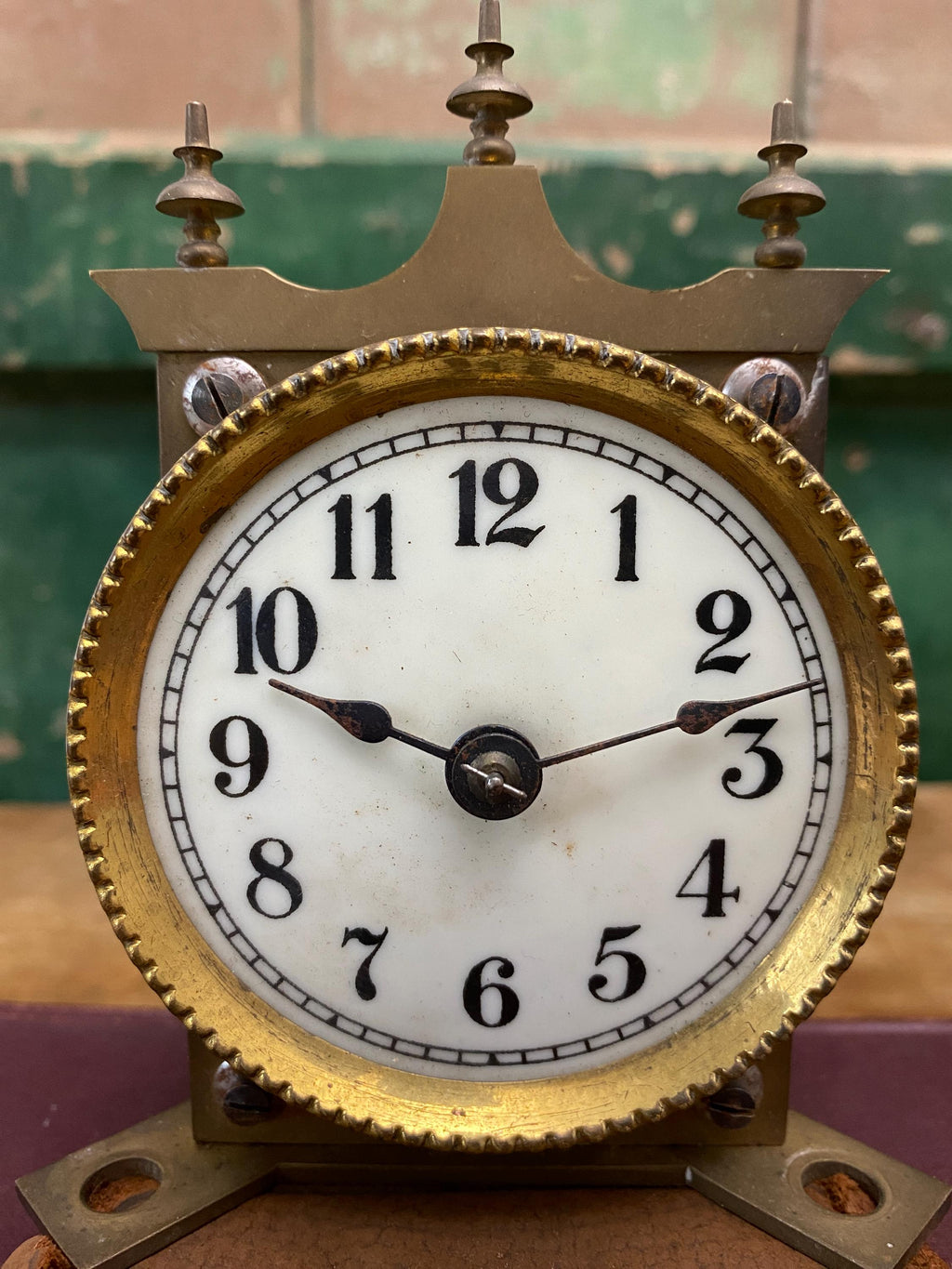 Vintage clock with gold frame and white face showing time.