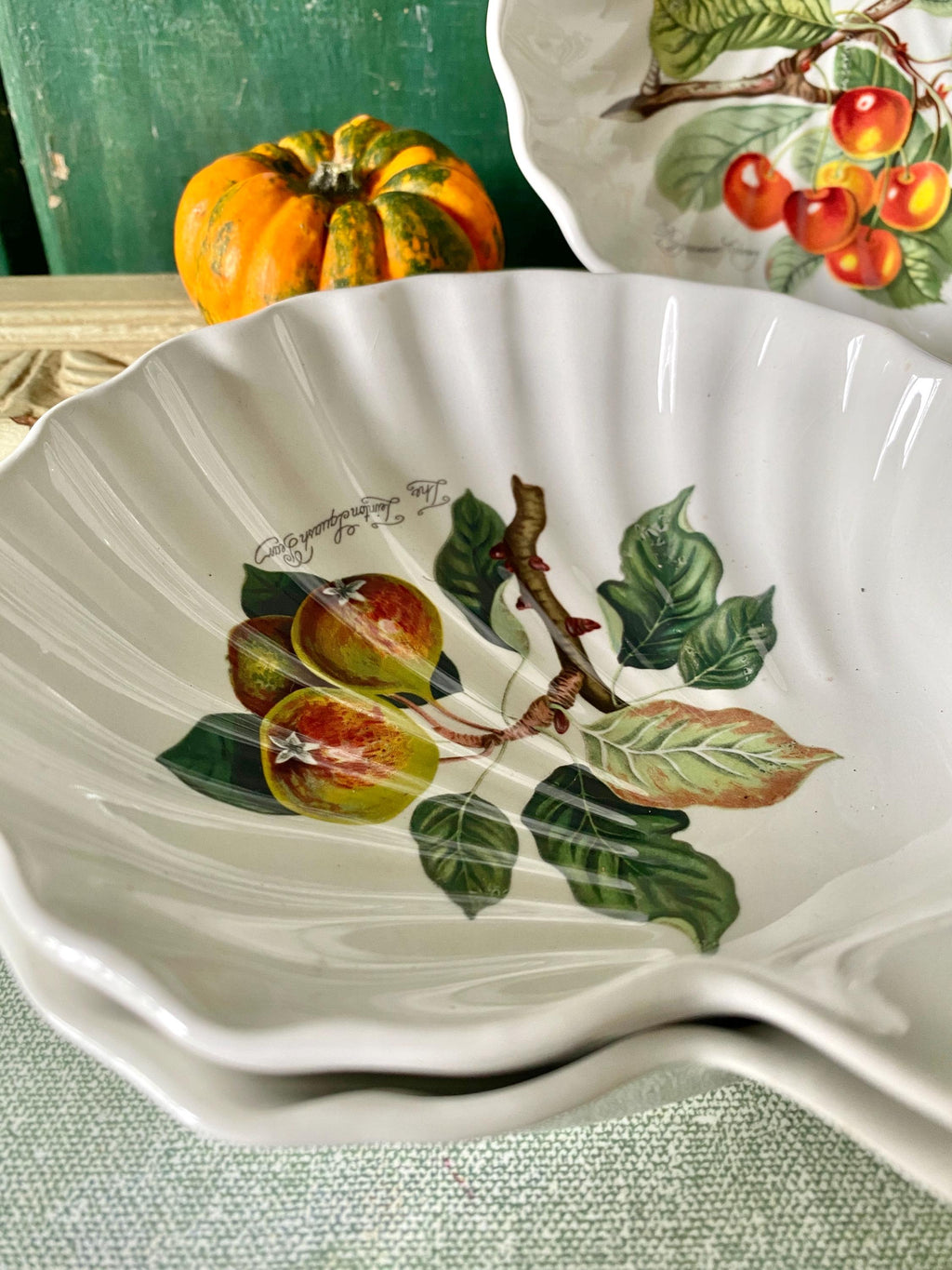 Three decorative ceramic dishes with fruit designs