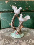 Decorative ceramic piece with two white birds on a natural wood branch