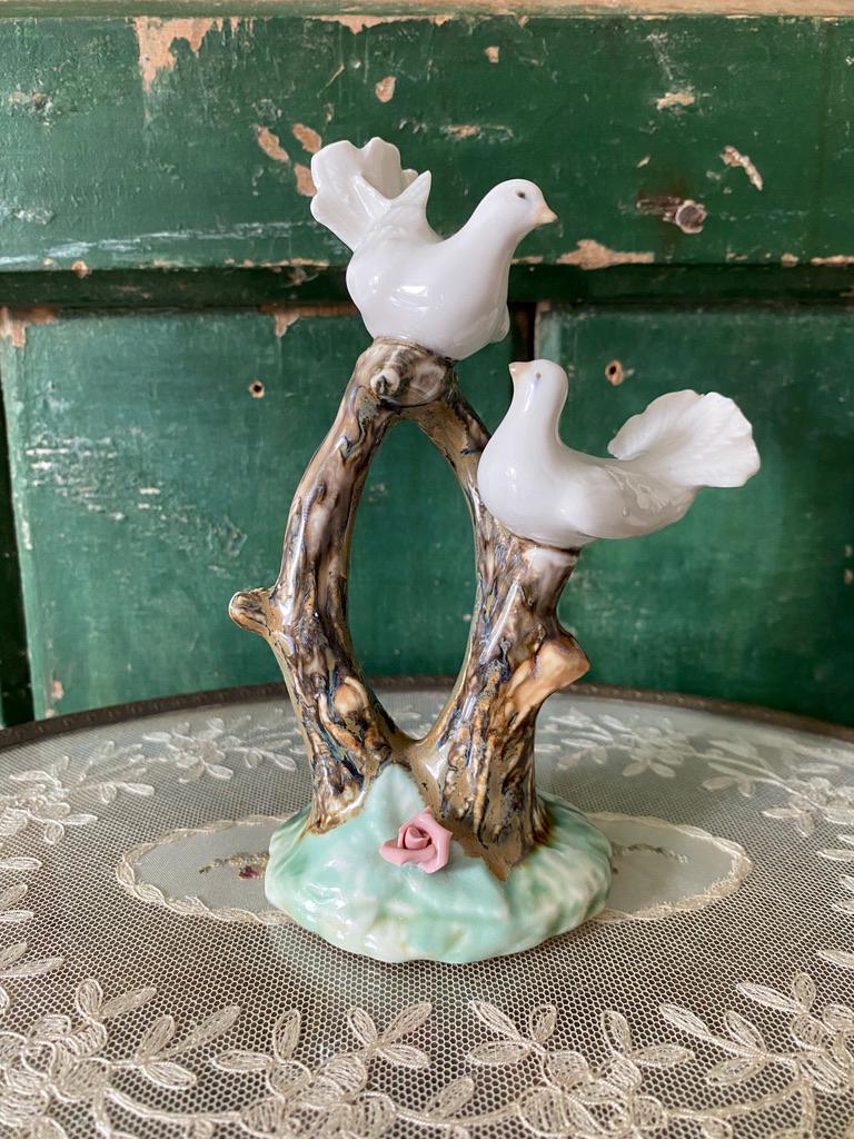 Decorative ceramic piece with two white birds on a natural wood branch