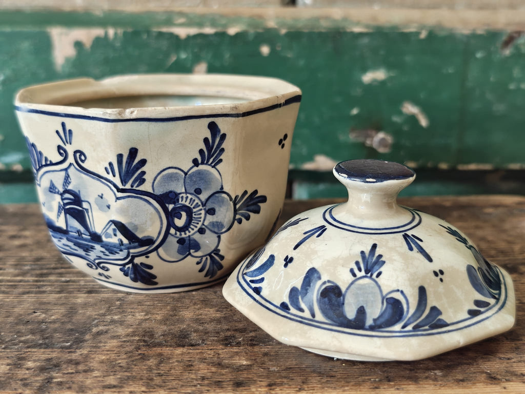 A vintage blue-and-cream ceramic lidded container or sugar bowl set, shown with the lid placed in front.