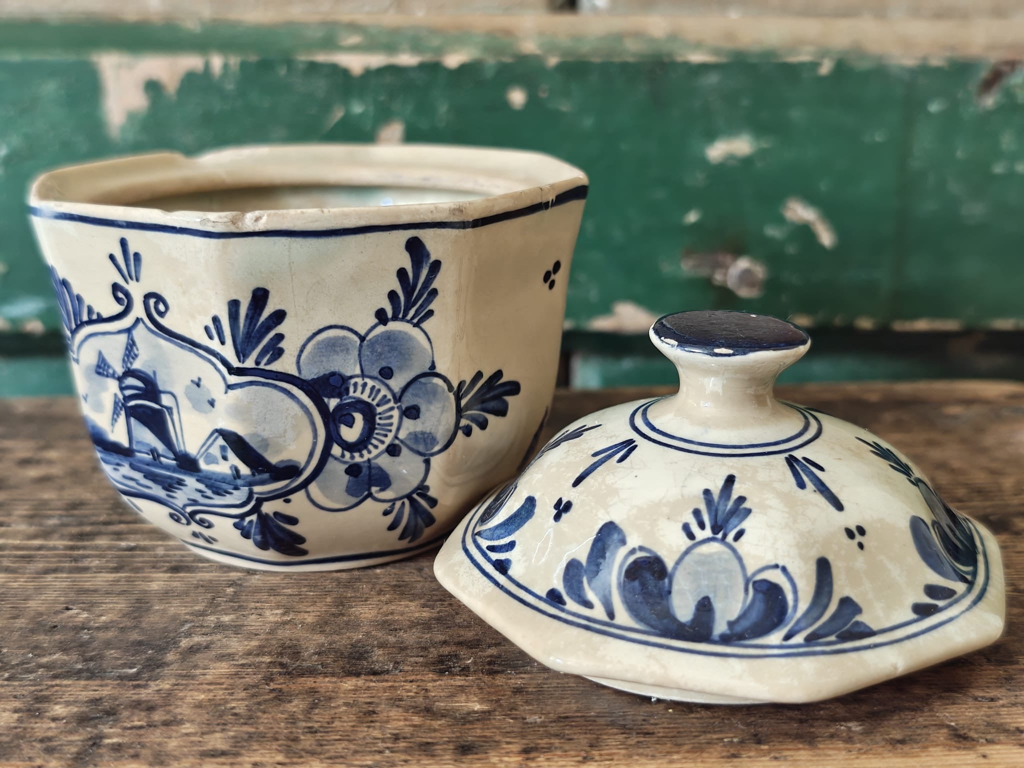 A vintage blue-and-cream ceramic lidded container or sugar bowl set, shown with the lid placed in front.