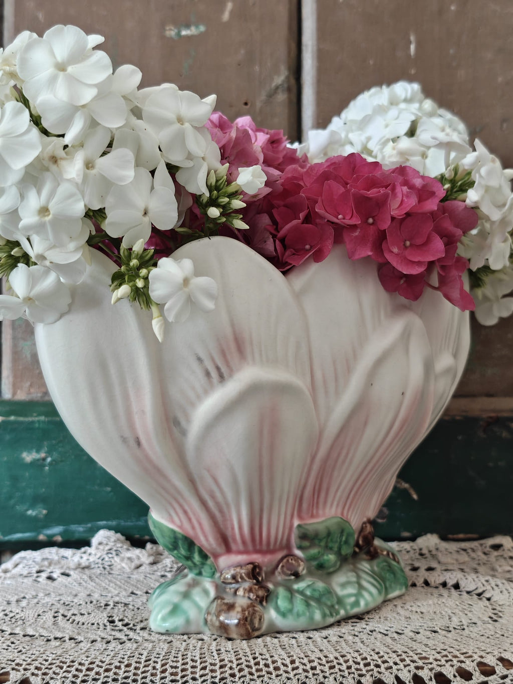 A vintage-style ceramic flower vase formed as a pink and green magnolia flower.