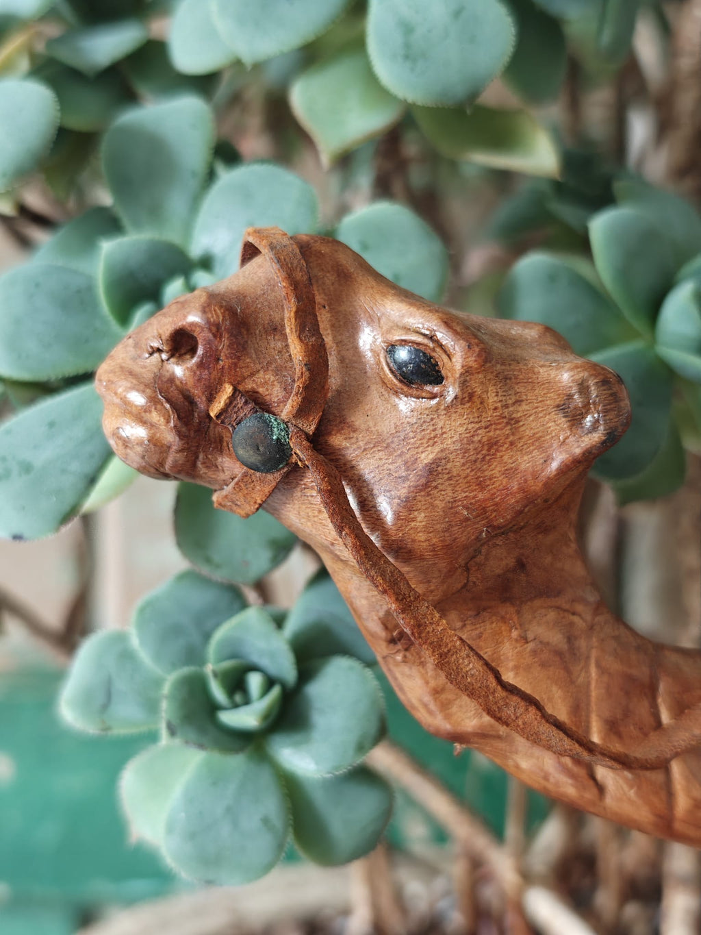 Close-up of the head of a brown leather covered camel figurine