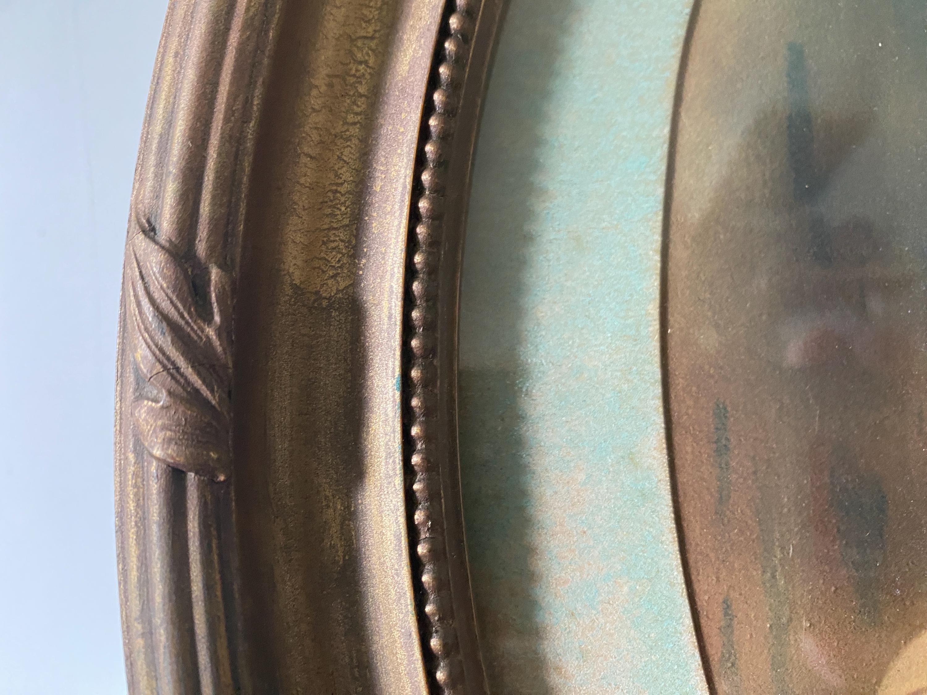 Close-up of part of an oval gold frame and picture mount