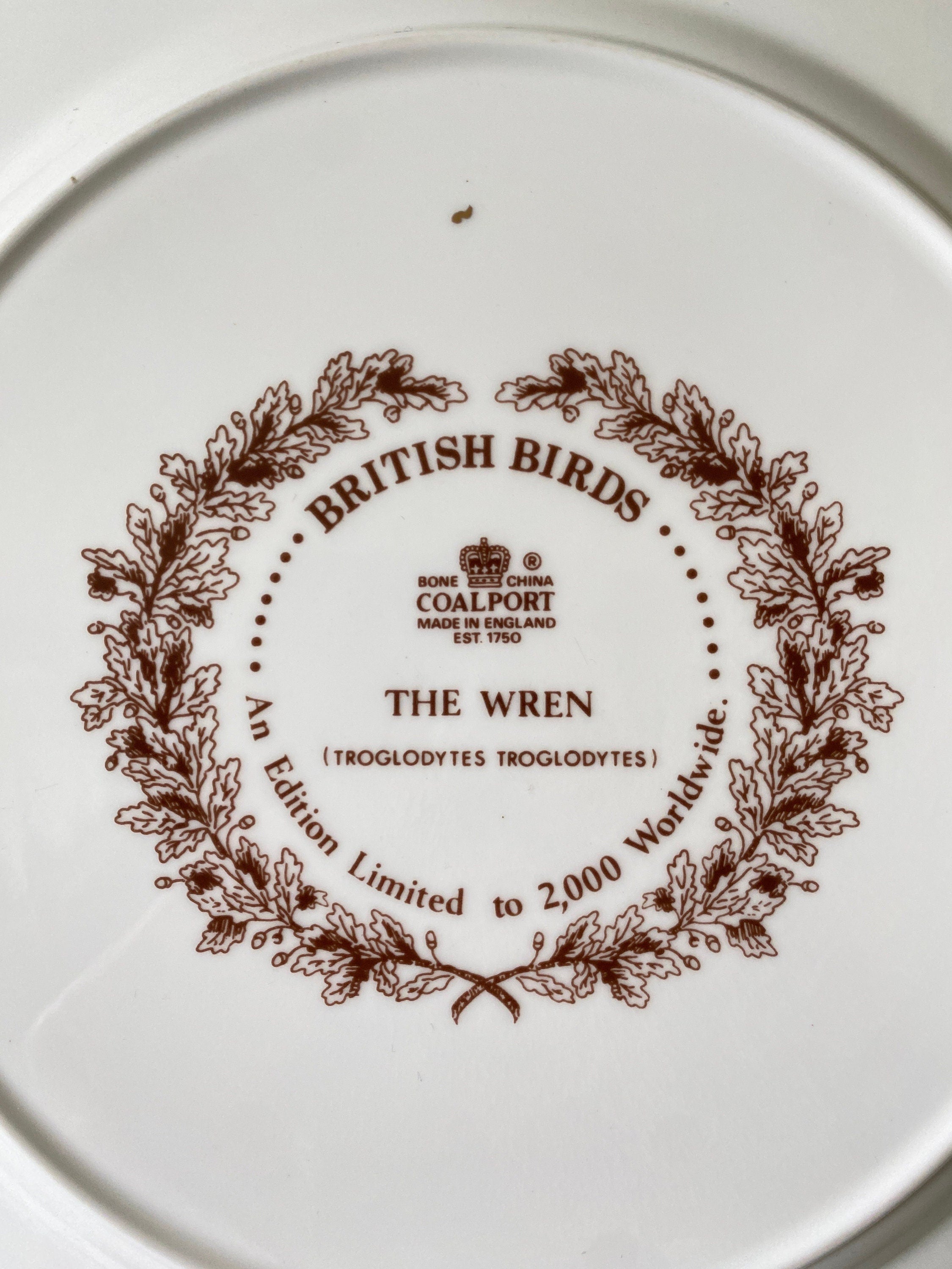White plate with brown text and design, featuring the Coalport brand.