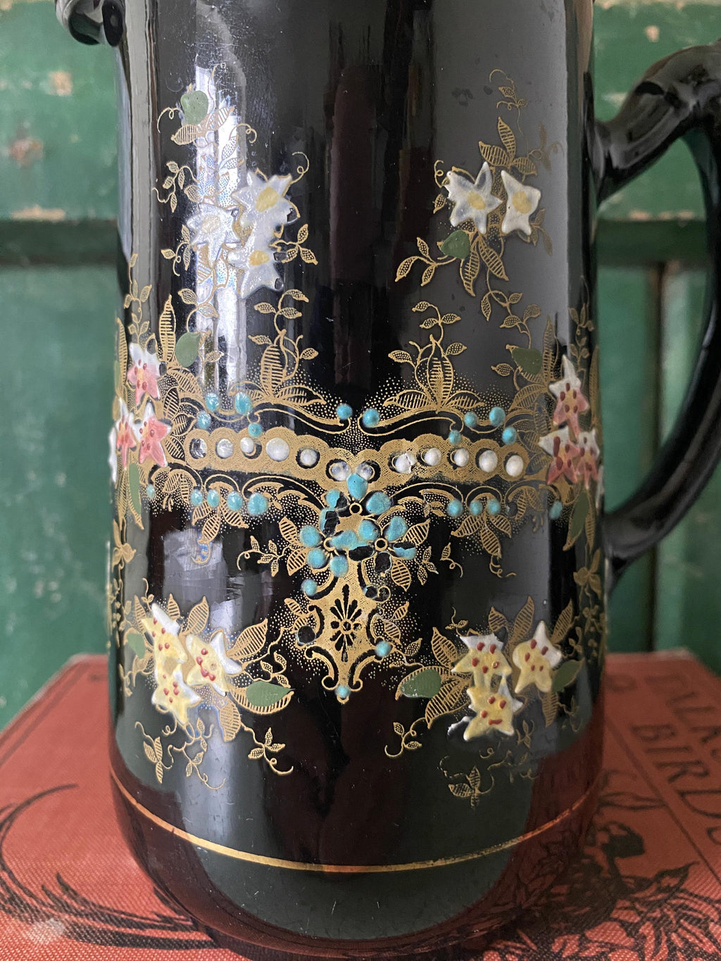close-up of intricate floral decoration on a black jug 