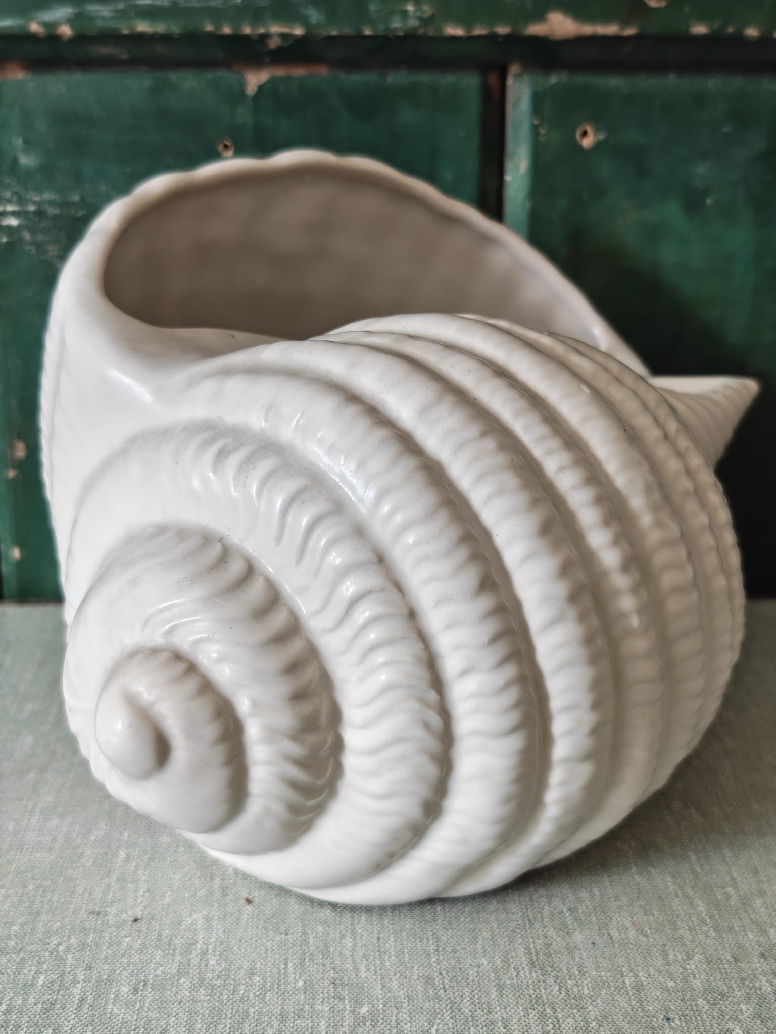 A large vintage white ceramic seashell planter with a glazed finish.