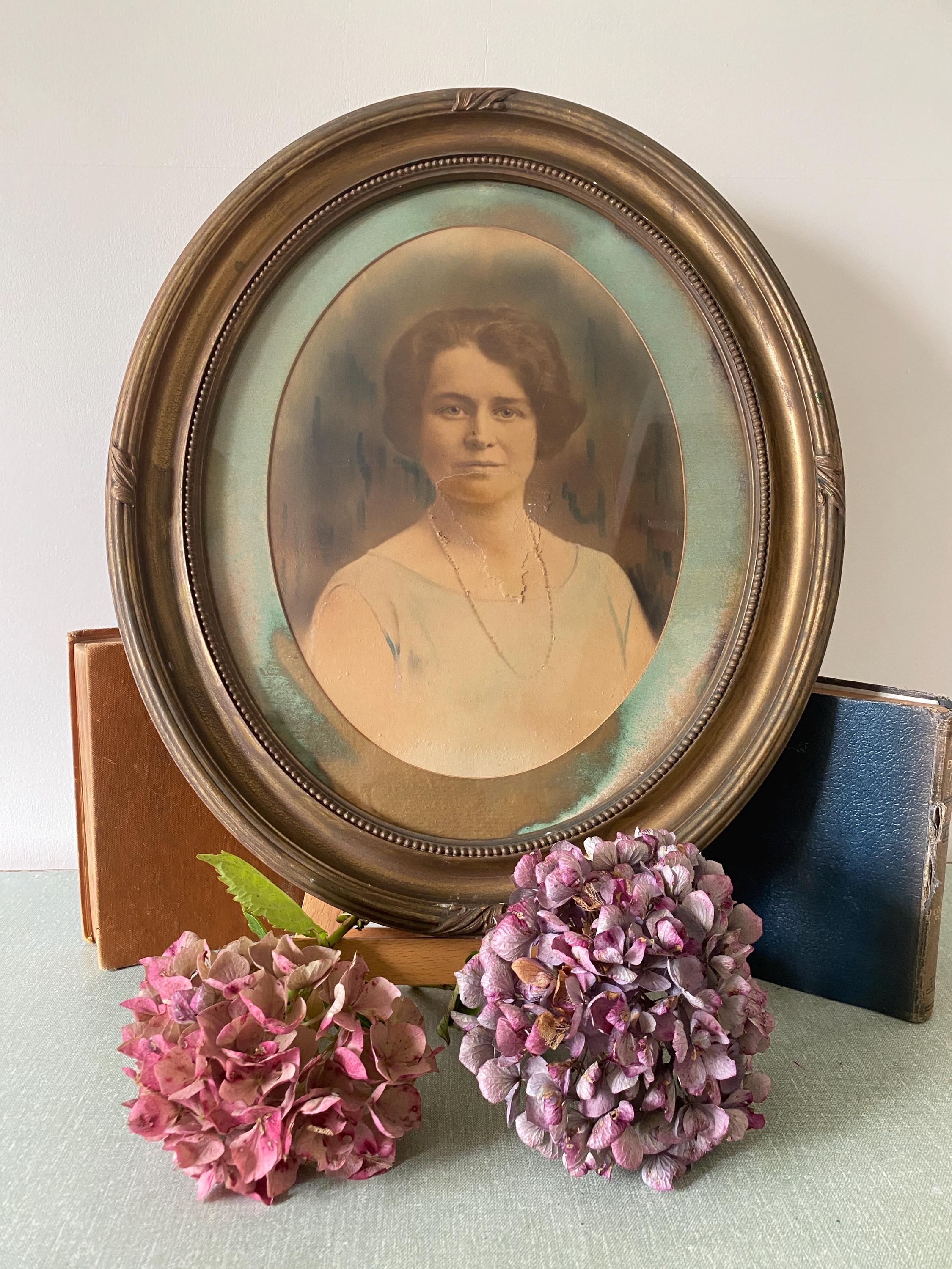 Vintage portrait of a woman in an oval gold frame