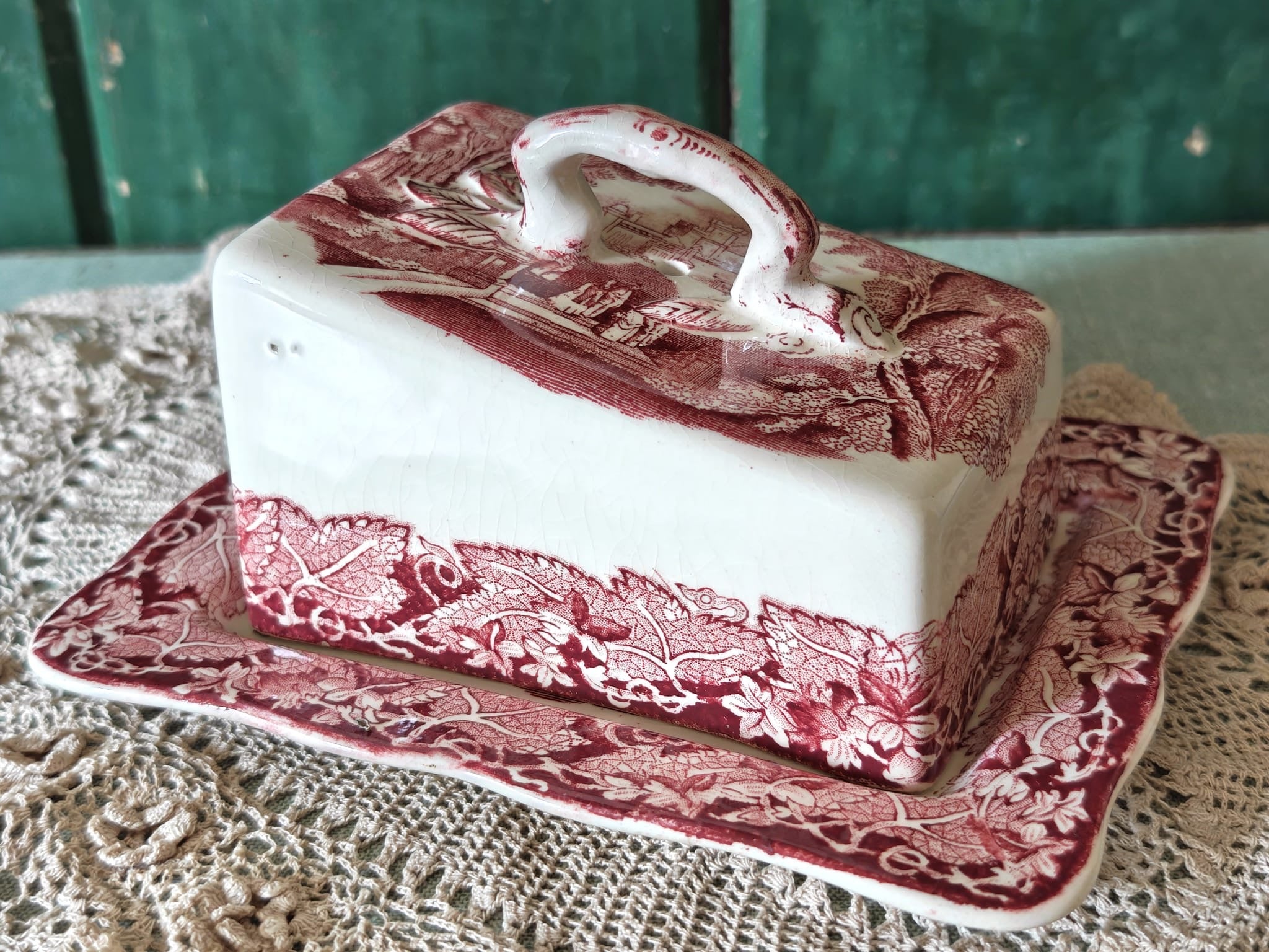 A Masons Vista butter dish with a lid, featuring a pink toile pattern.