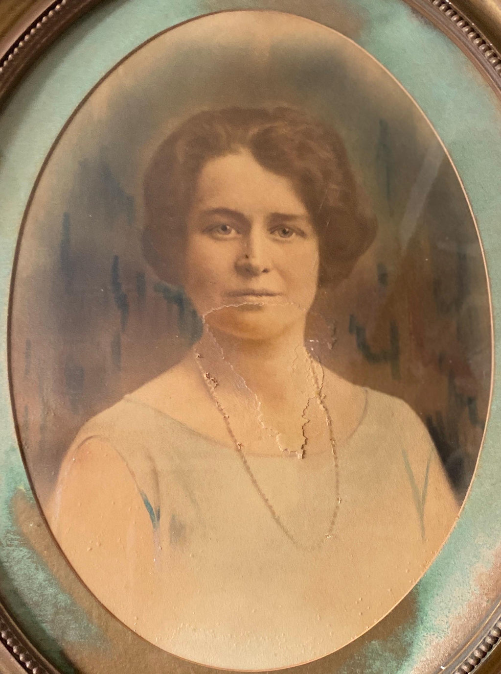 Vintage portrait of a woman in an oval gold frame and mount