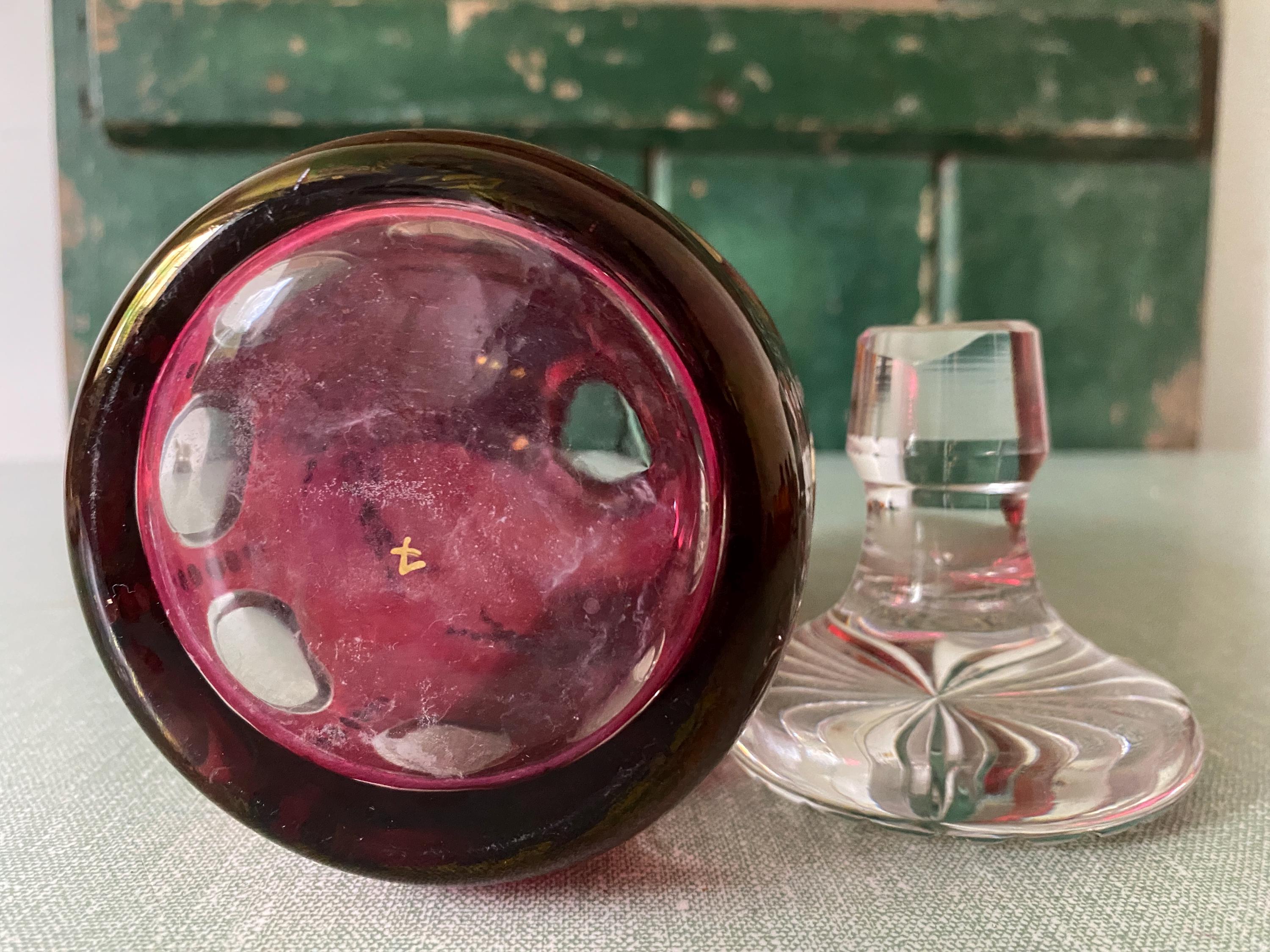 base of red gass decanter with glass stopper