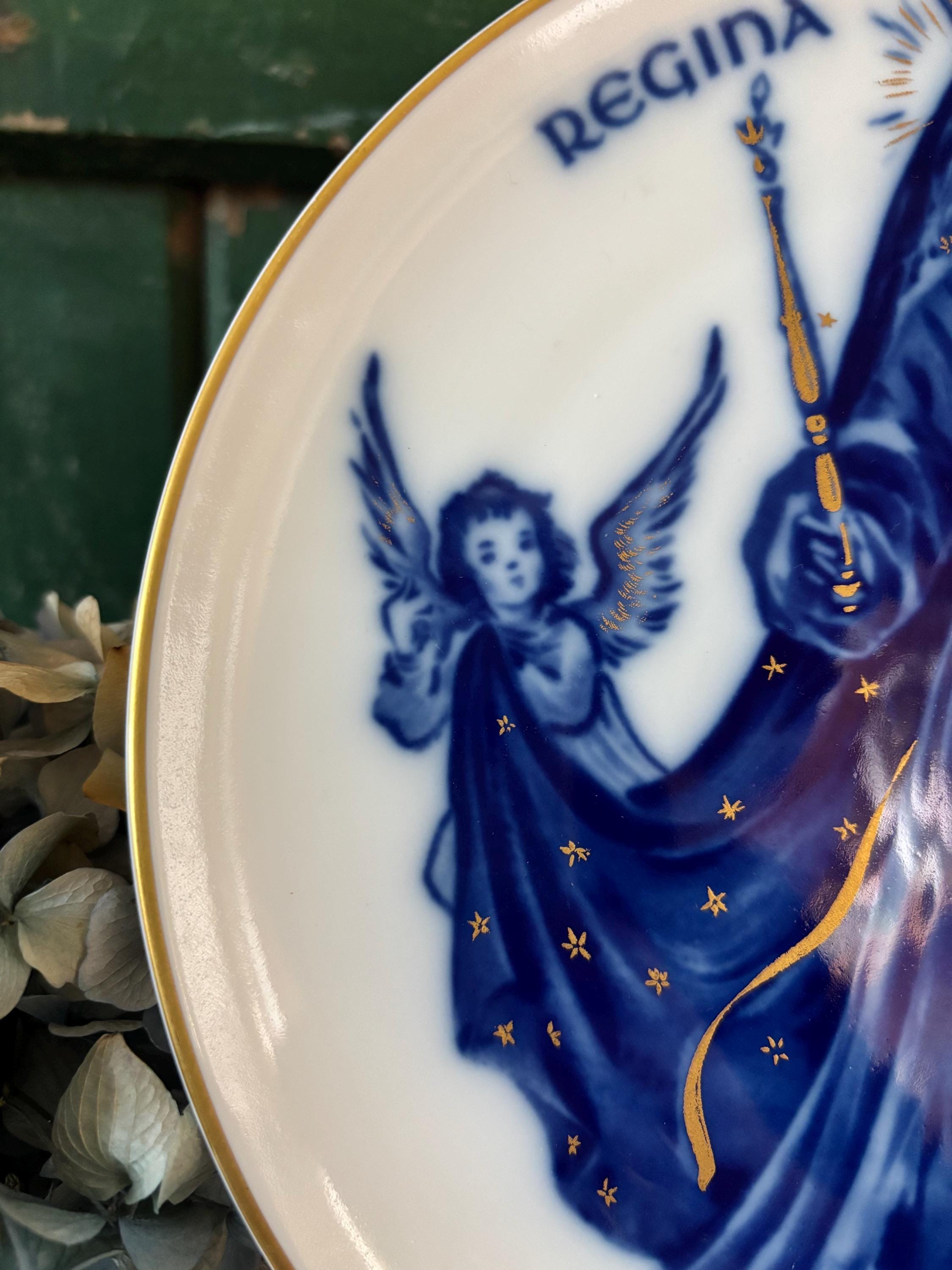 Close-up detail of decorative plate with blue and gold religious design showing an angel