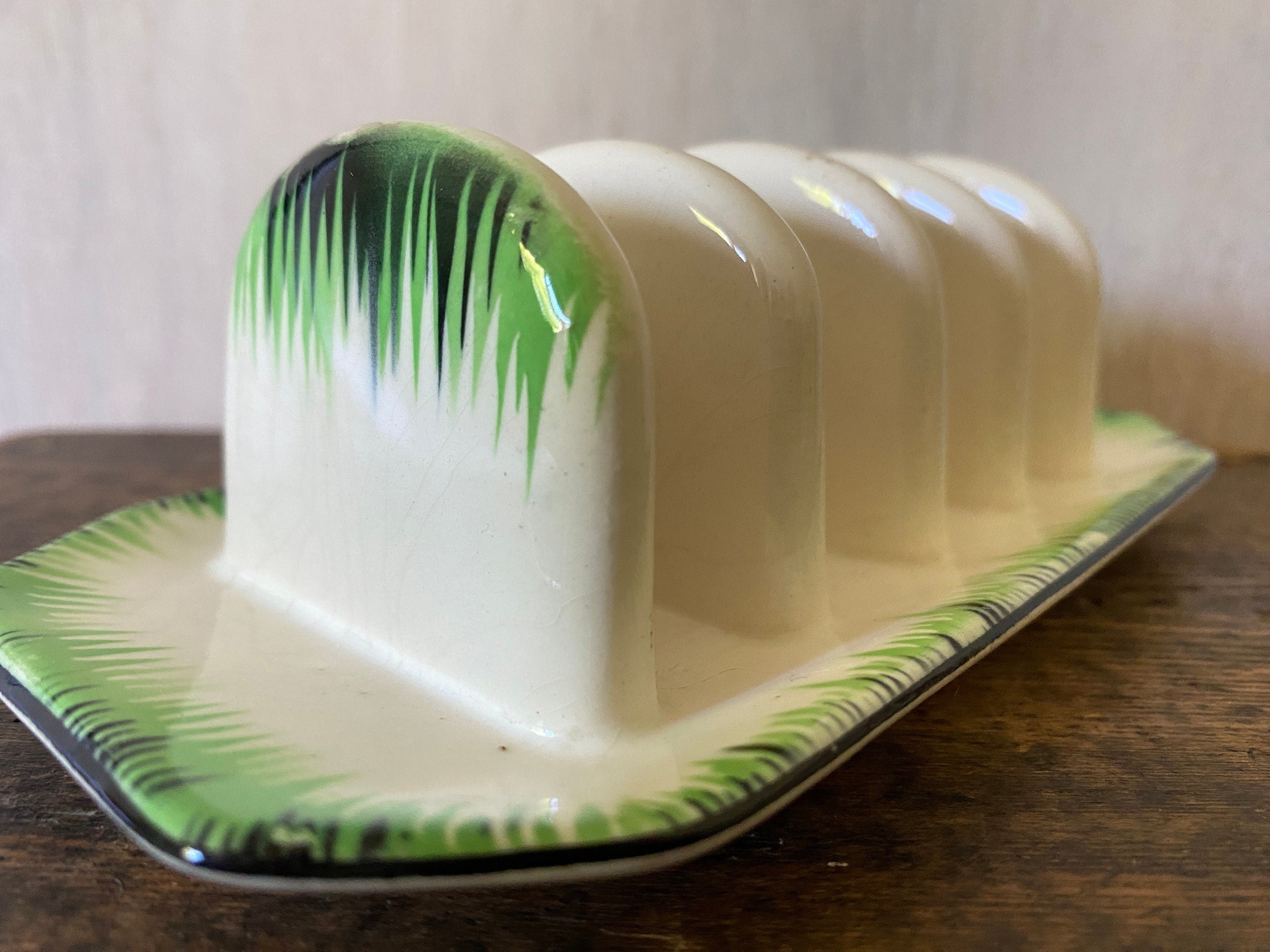 close-up of a green and black decoration on a ceramic toast rack