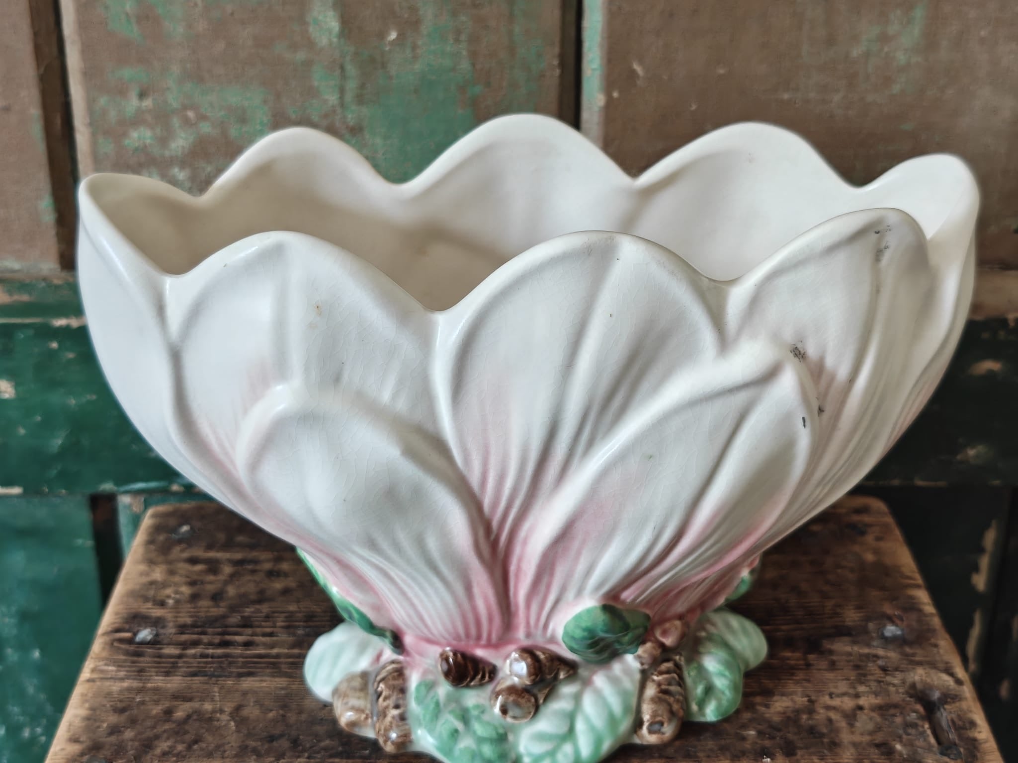 A vintage-style ceramic flower vase formed as a pink and green magnolia flower.