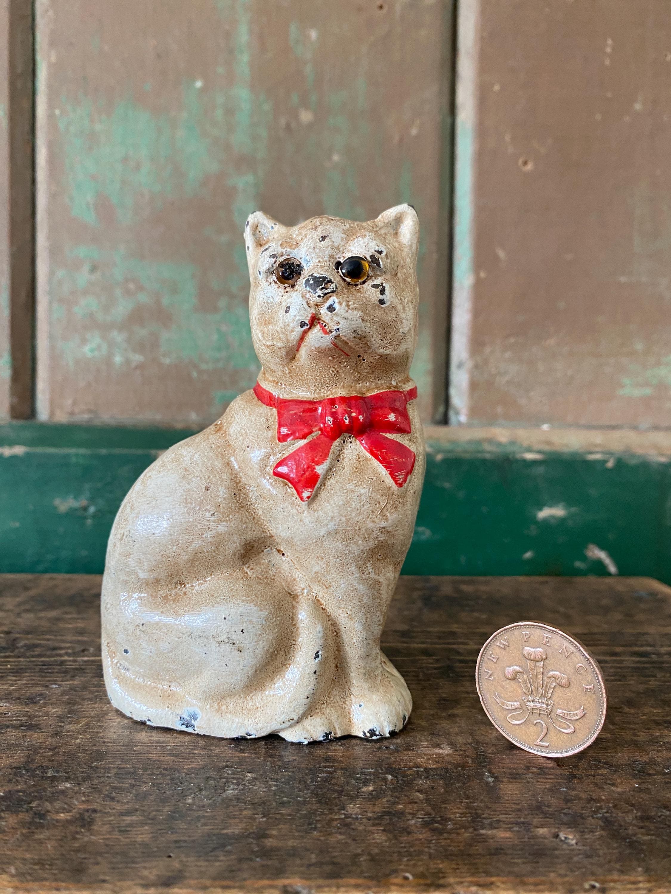 Small figurine of a white cat  with a red bow