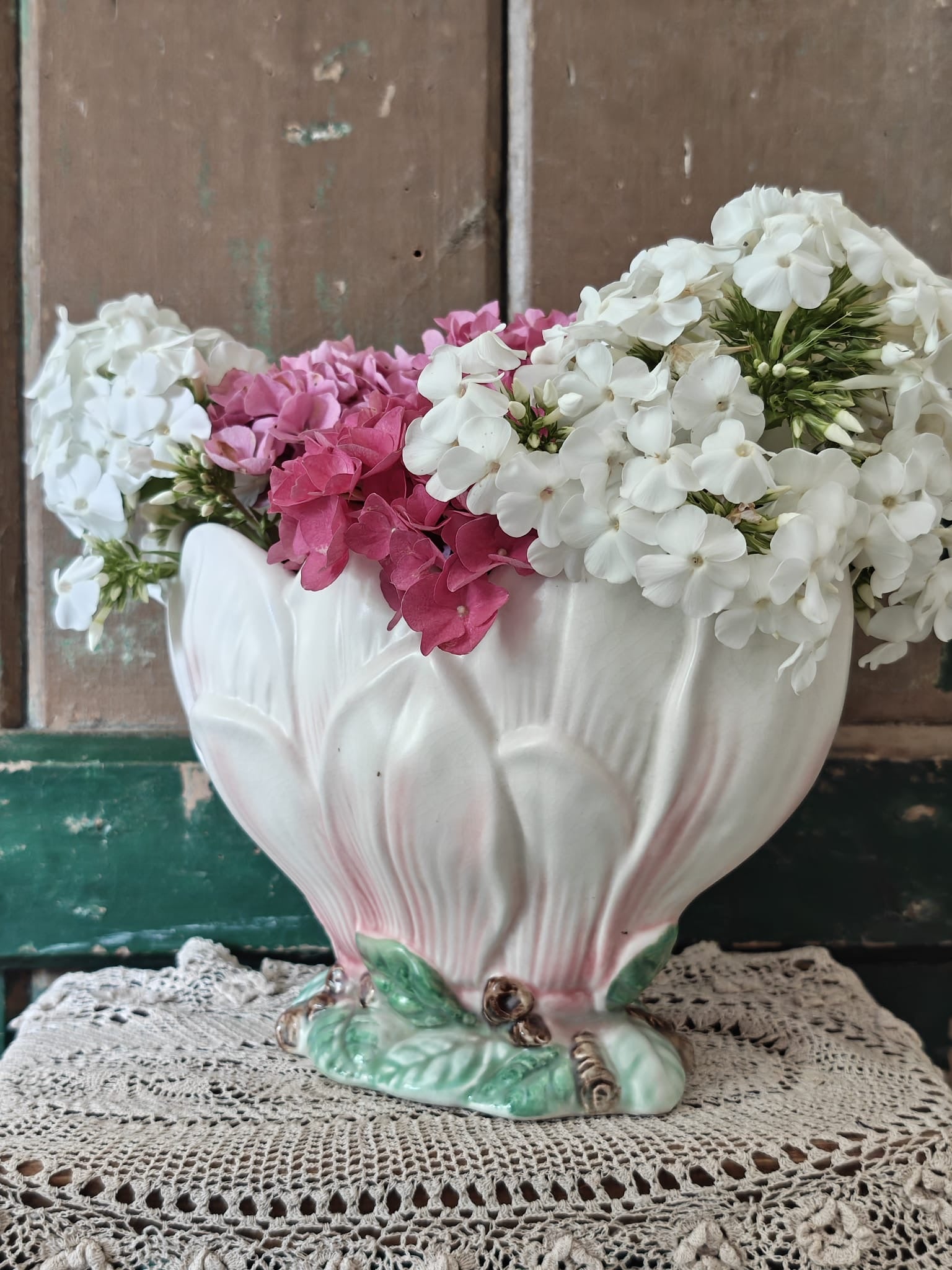 A vintage-style ceramic flower vase formed as a pink and green magnolia flower.