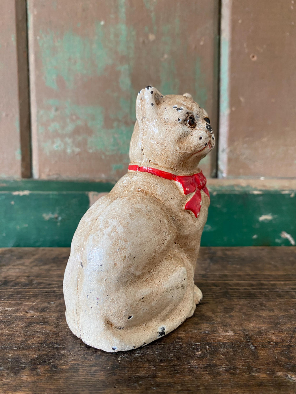 Small figurine of a white cat  with a red bow