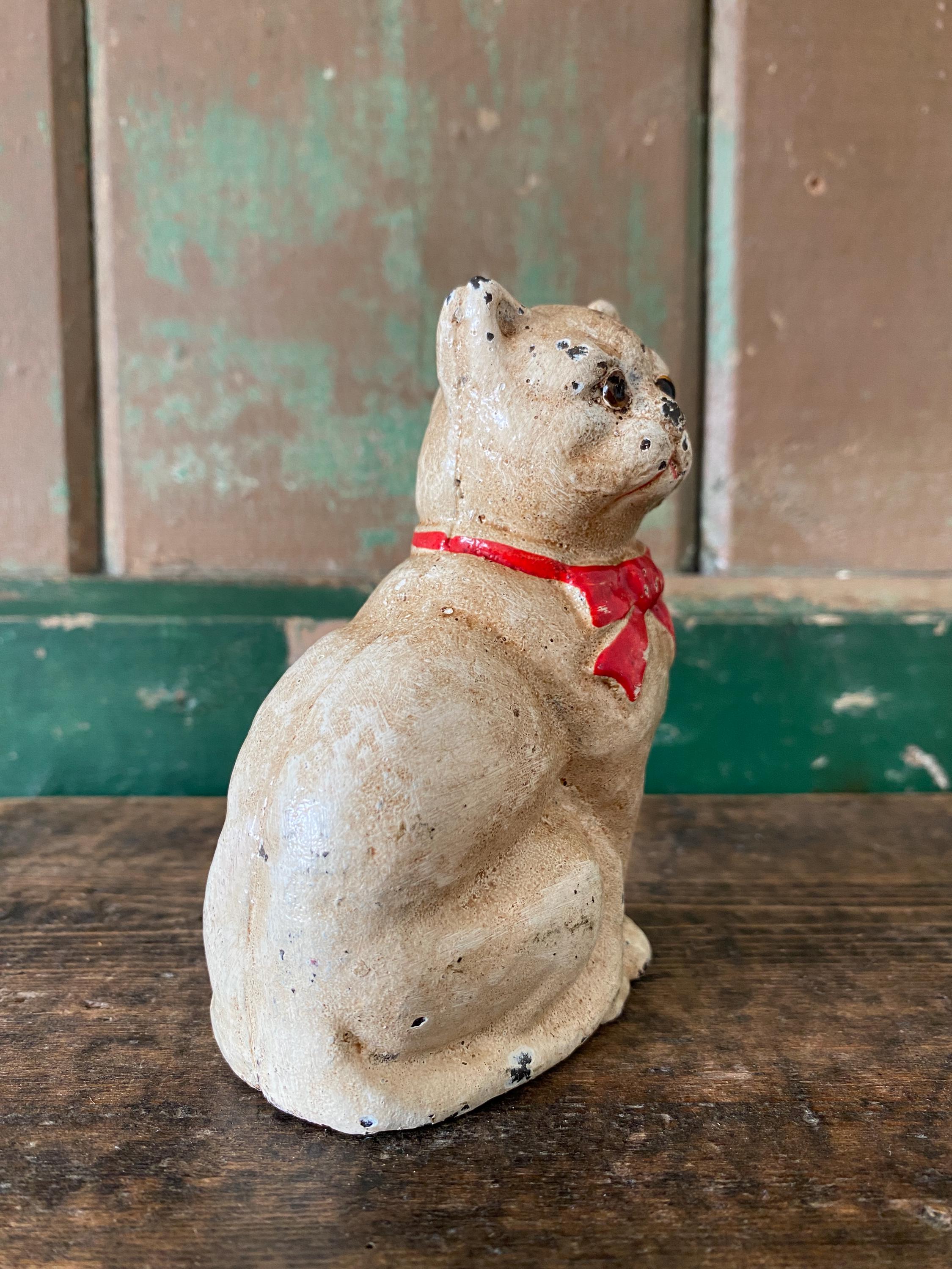 Small figurine of a white cat  with a red bow