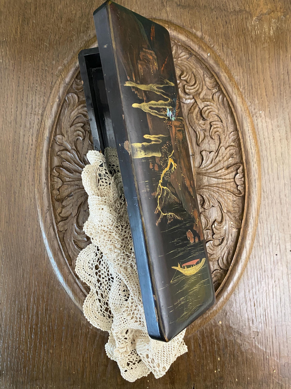 Partly open decorative wooden box with oriental style landscape picture