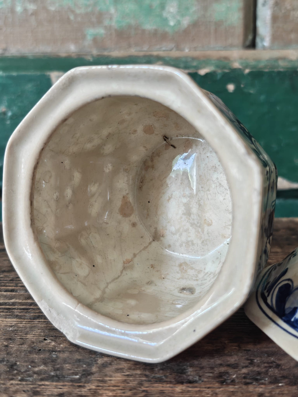 A vintage blue and white hand-painted stoneware lidded sugar bowl showing interior.