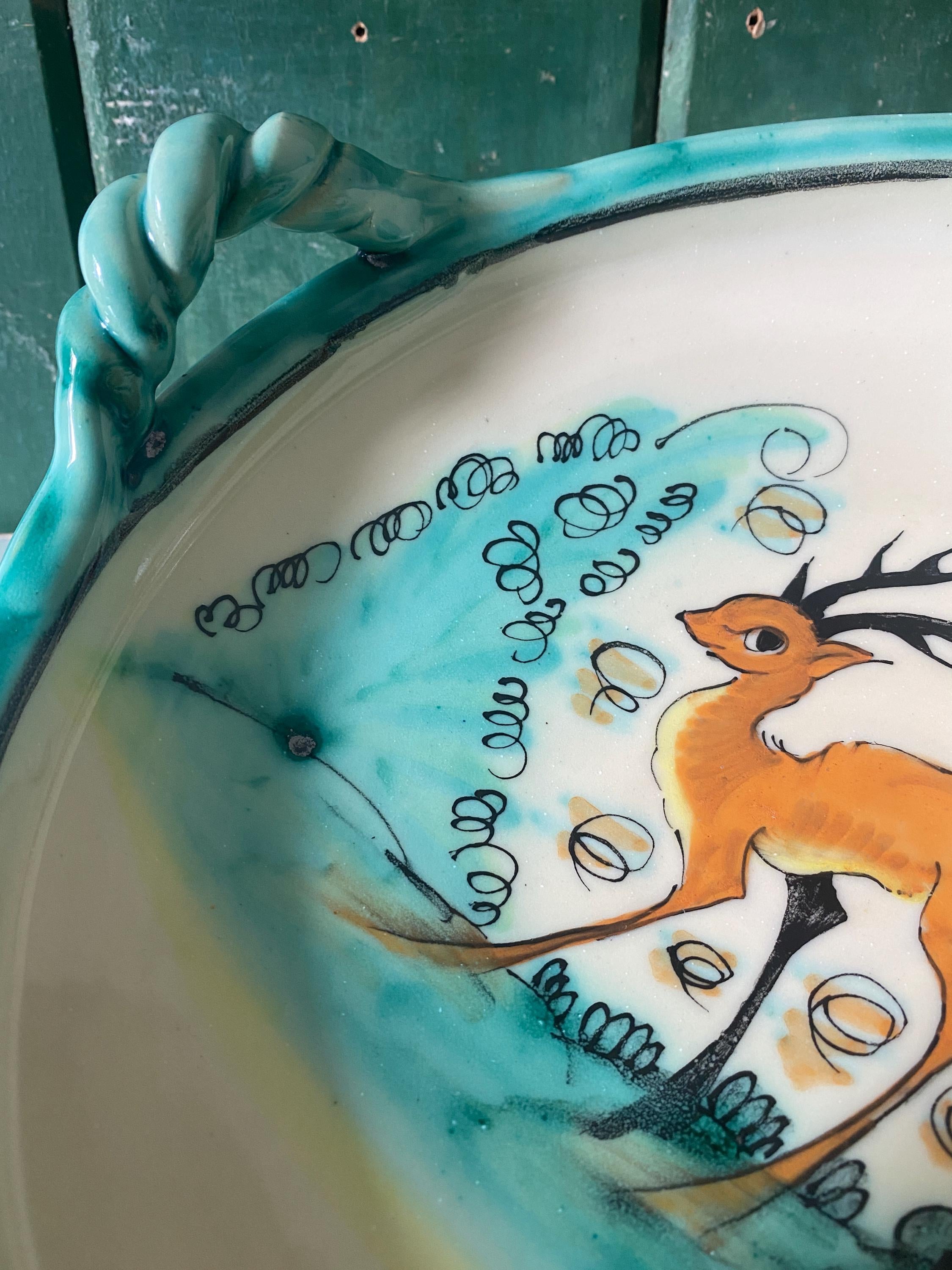 Detail of a ceramic bowl showing deer design and handle