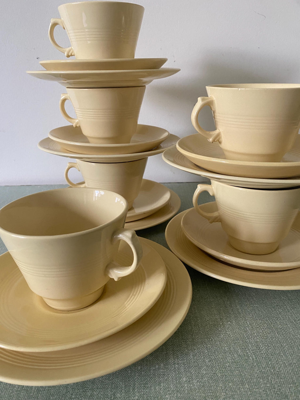 A group of yellow ceramic cups, saucers and plates 