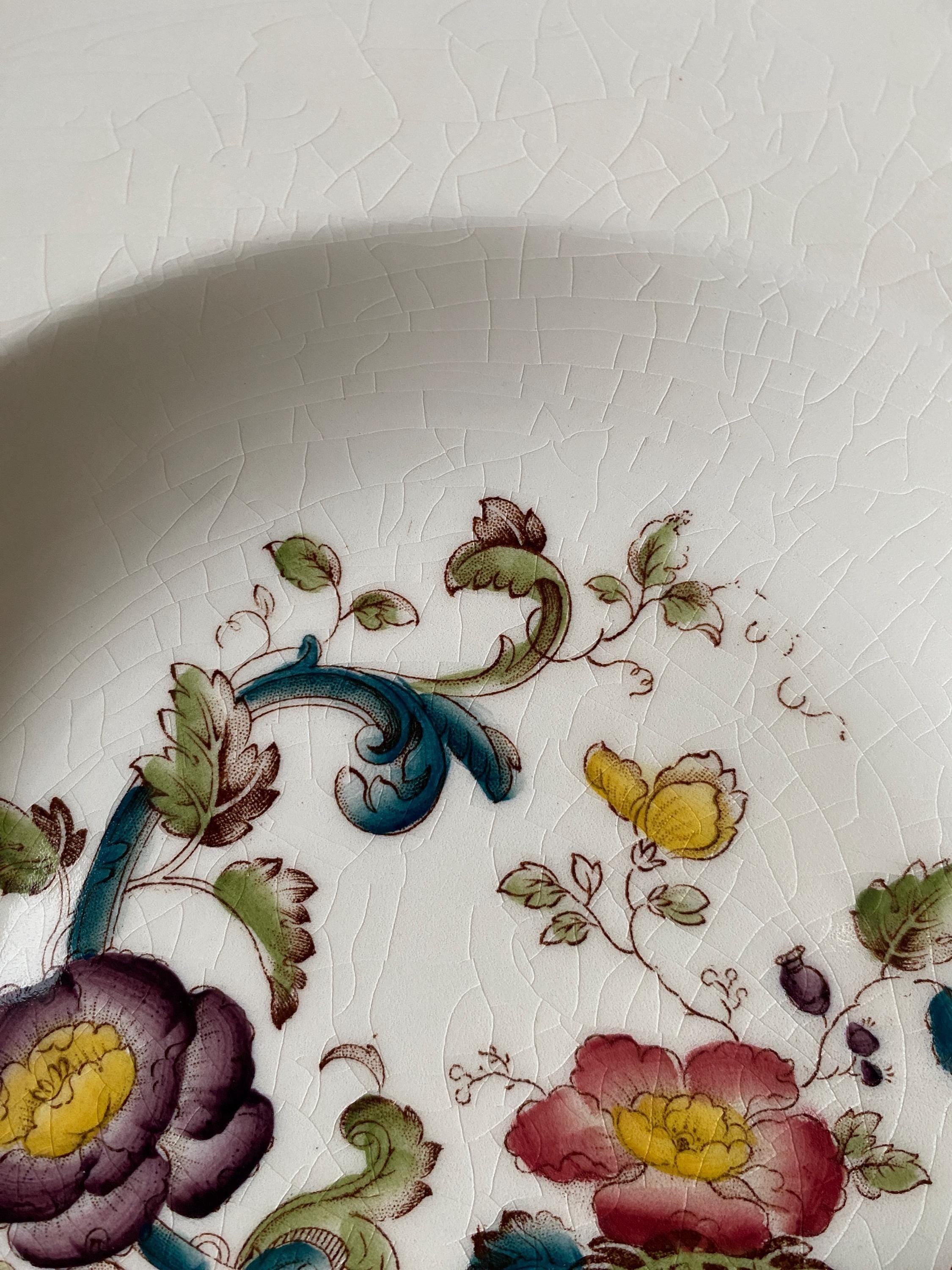 Close-up of a ceramic plate with floral patterns on a white background