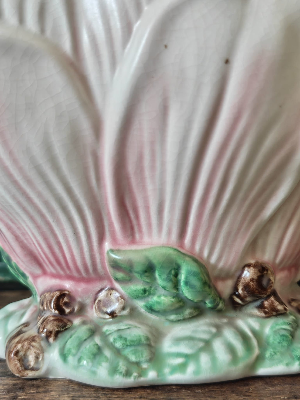 Close-up of a vintage-style ceramic flower vase formed as a pink and green magnolia flower.