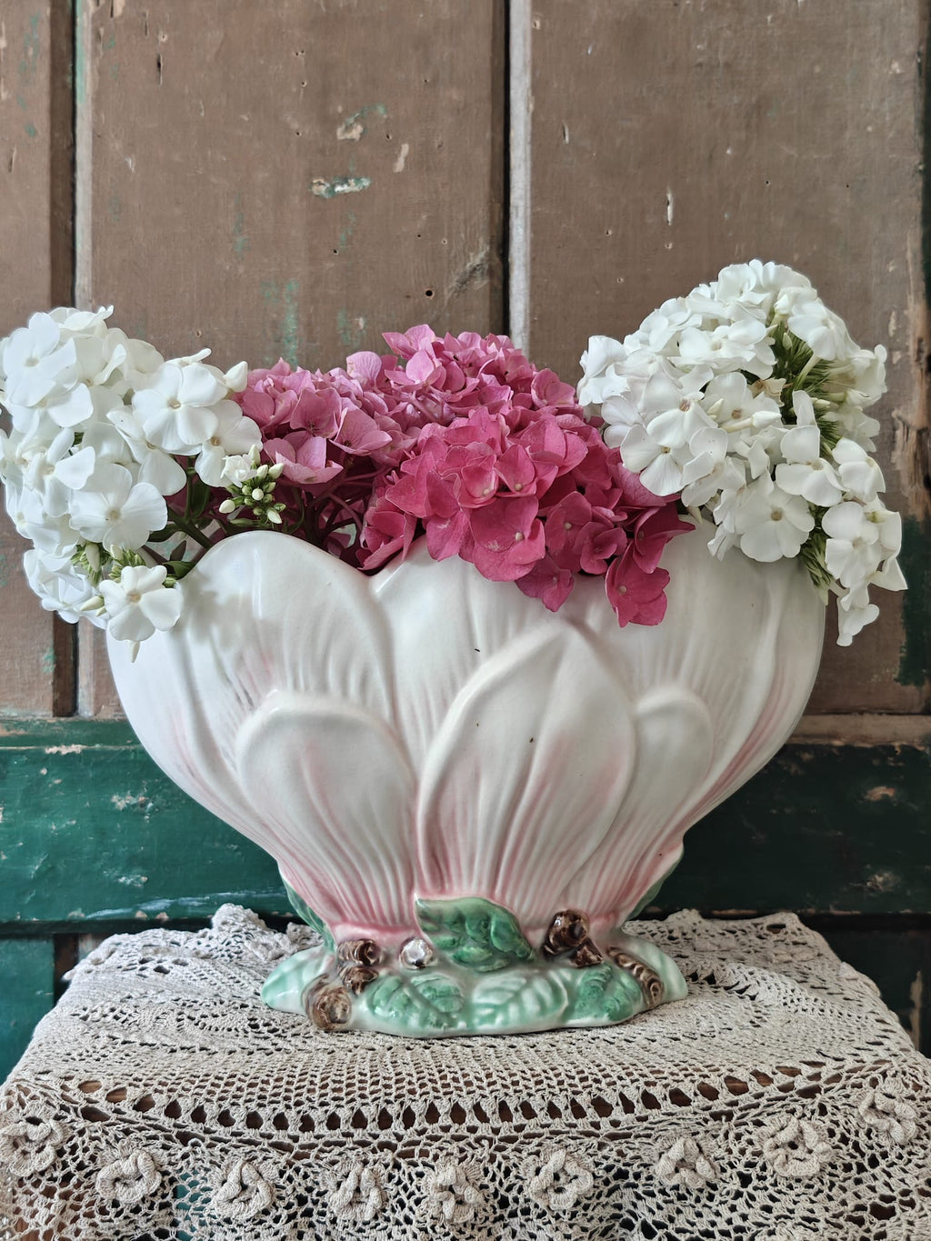 A vintage-style ceramic flower vase formed as a pink and green magnolia flower.