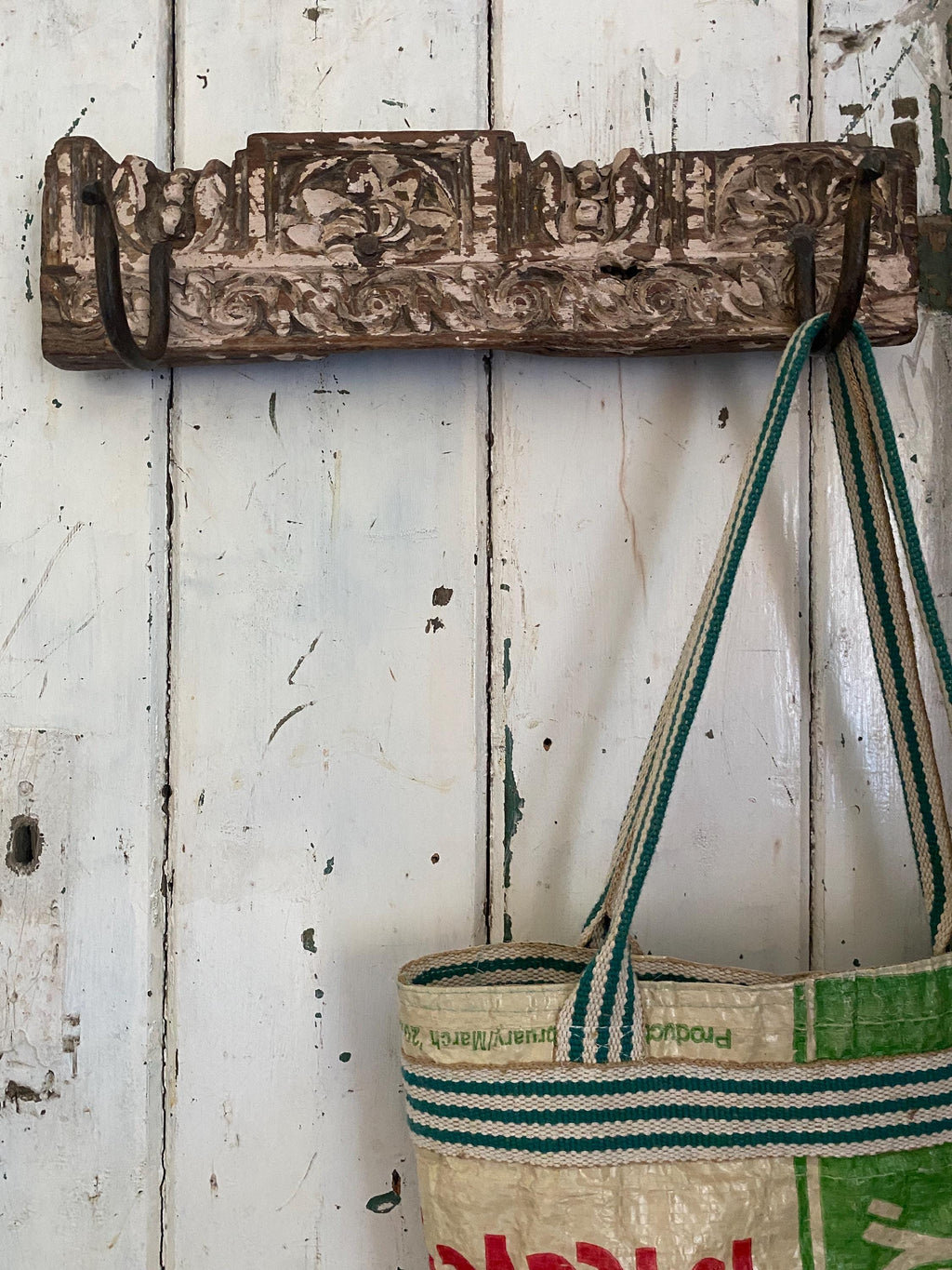 Vintage wooden hook with a striped bag hanging on it 