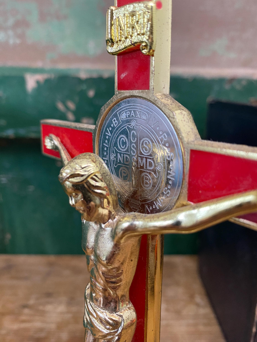 Close-up of a gold and red decorative crucifix with an inset silver medallion