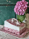 A Mason's ceramic butter dish with a pink toile pattern lid and base.
