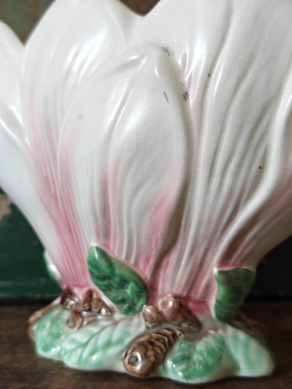 Close-up of a vintage-style ceramic flower vase formed as a pink and green magnolia flower.