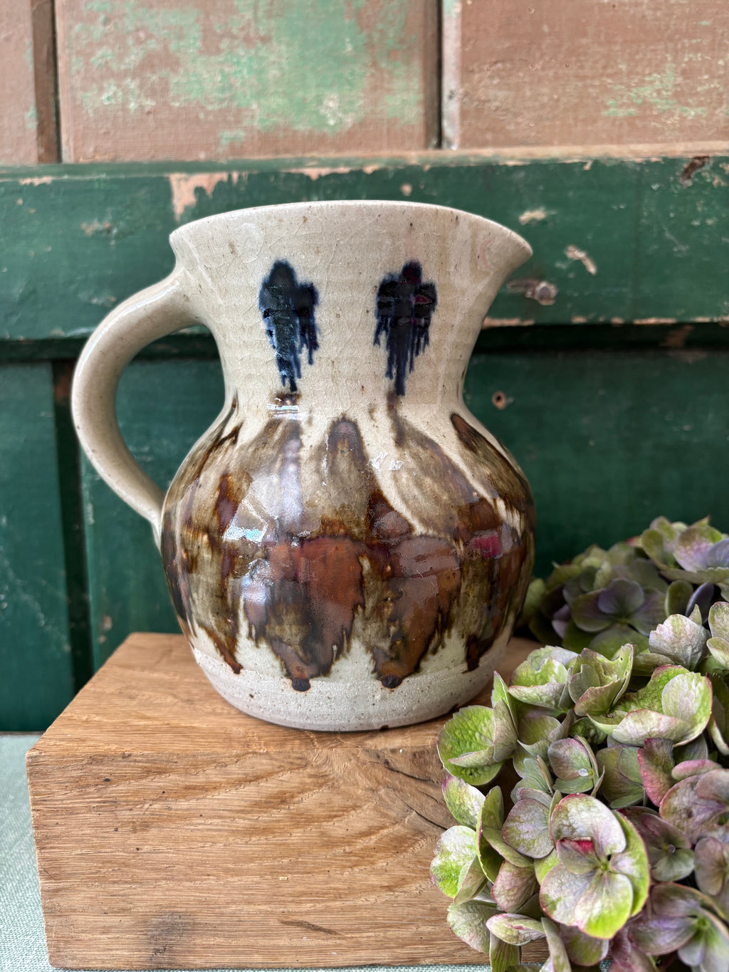 A handmade ceramic pitcher with a cream-colored glaze base.