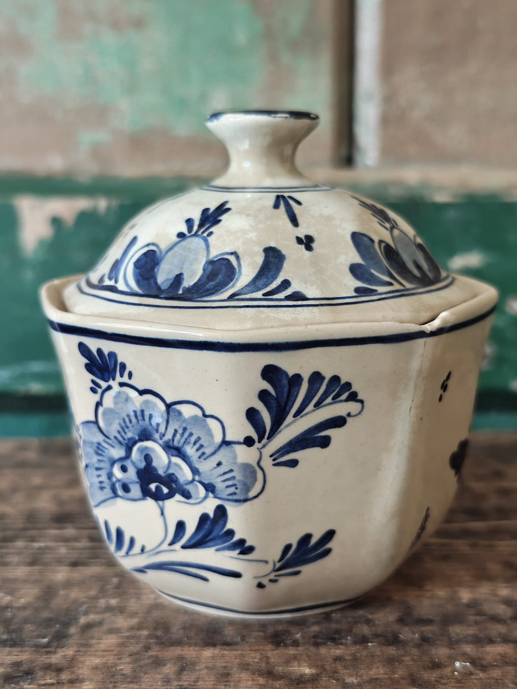 A vintage blue and white hand-painted stoneware lidded sugar bowl.