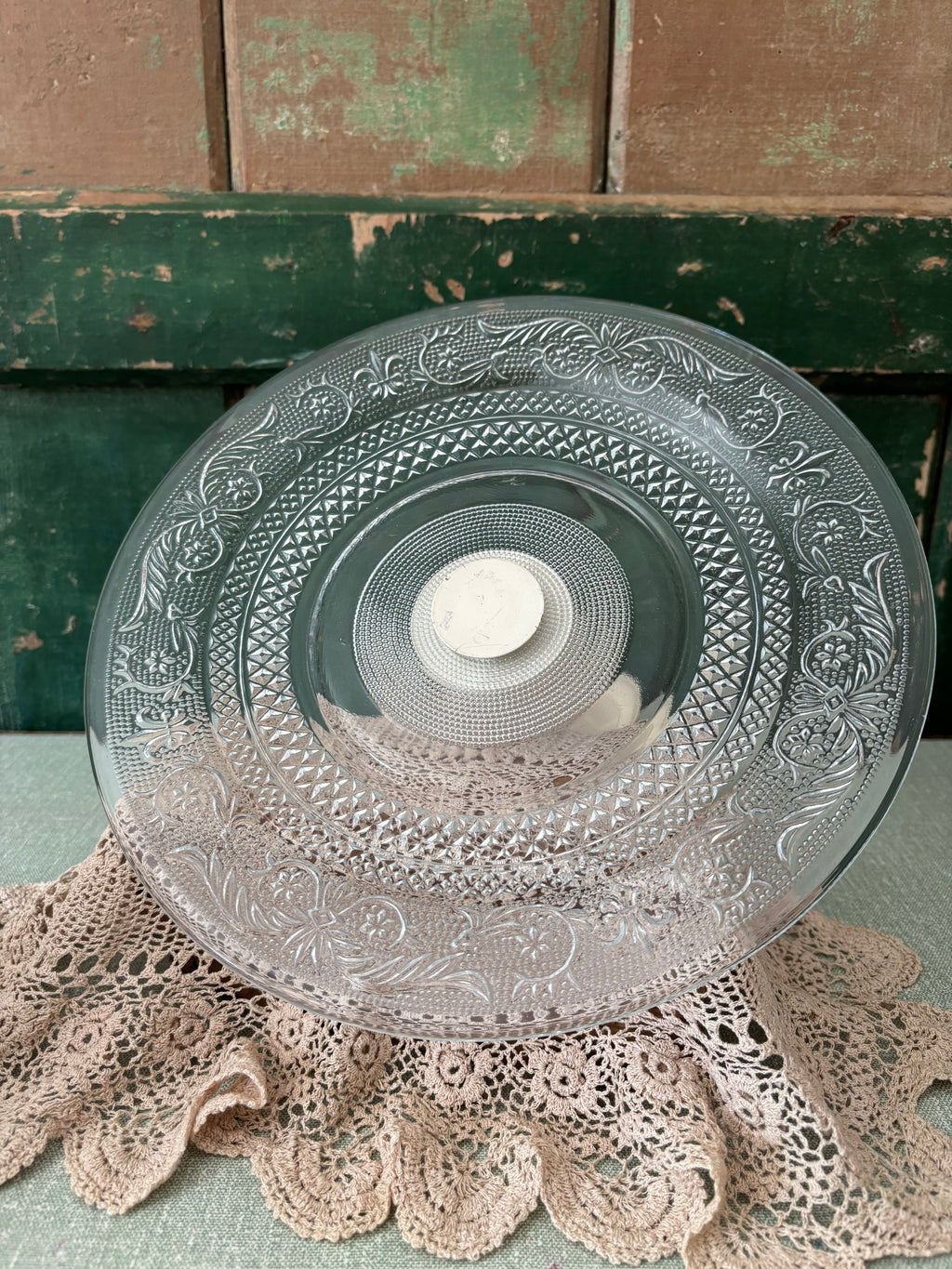 A clear cut-glass serving platter with ornate floral and geometric patterns.