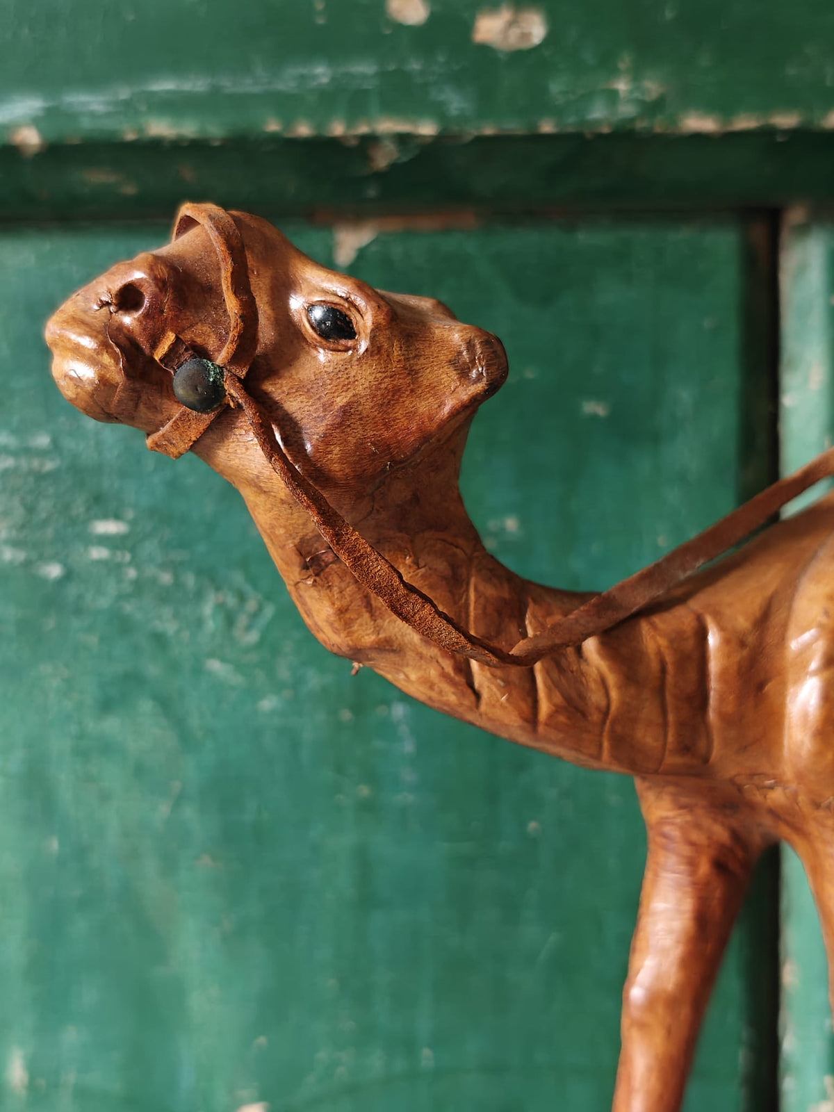 Close-up of the head and neck of a brown leather covered camel figurine