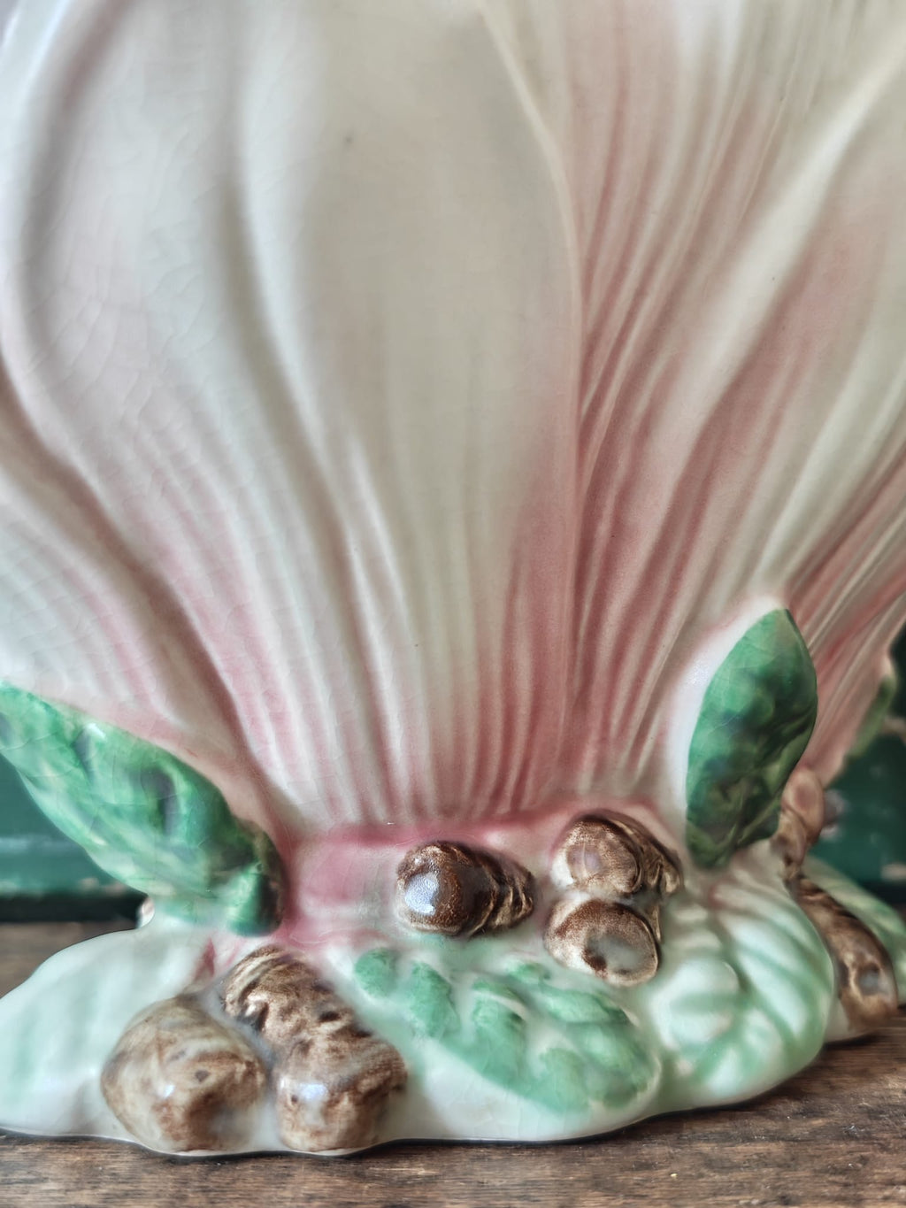 Close-up of vintage-style ceramic flower vase formed as a pink and green magnolia flower.